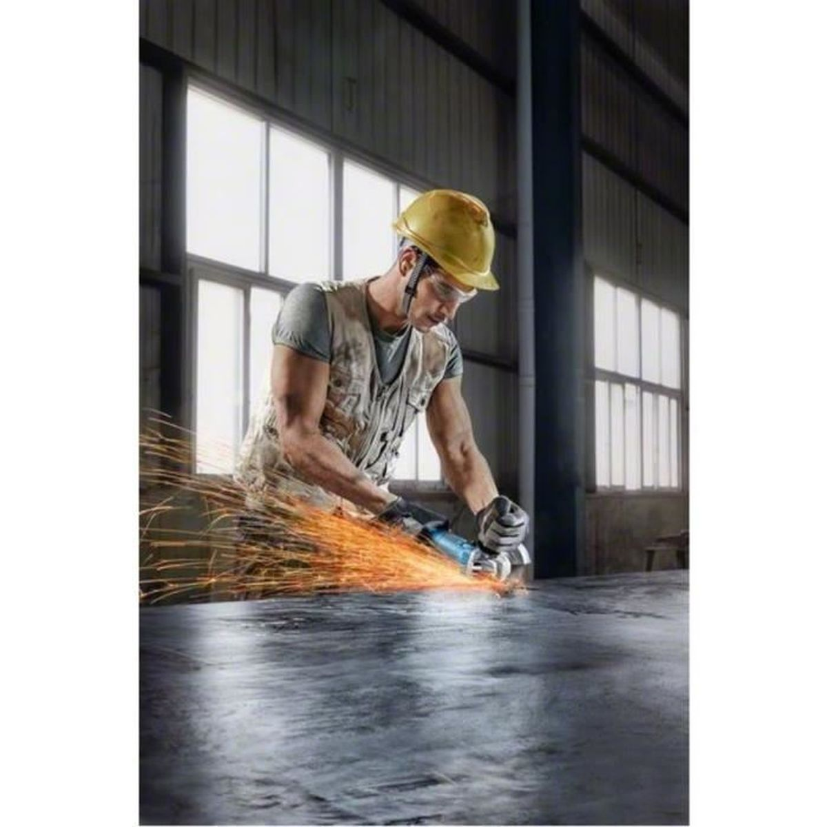 Ein Arbeiter mit Helm und Schutzbrille schneidet Metall mit einer Flex, wobei orangene Funken fliegen.