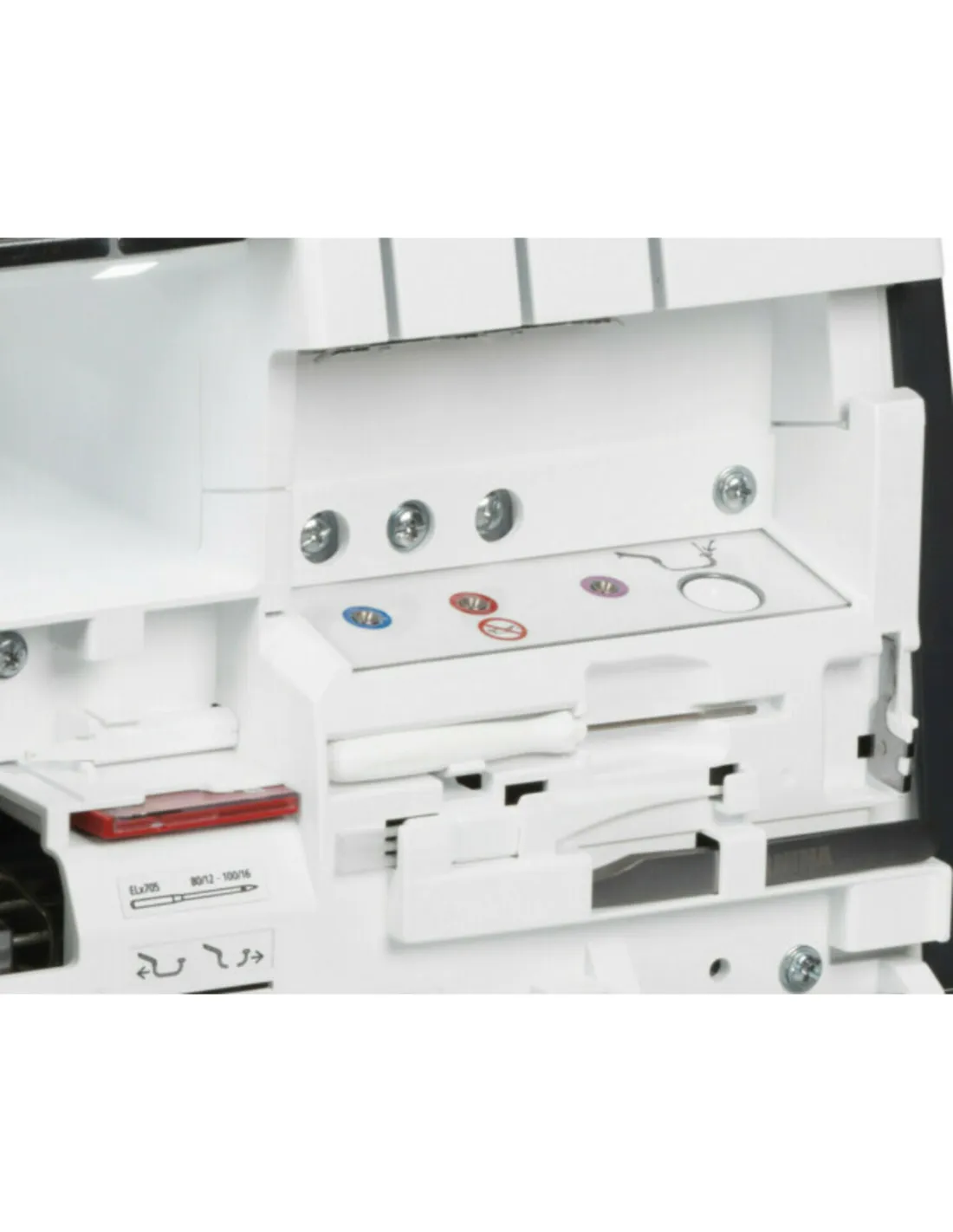 Close-up of the open thread guide area of a white sewing machine with colored markings.