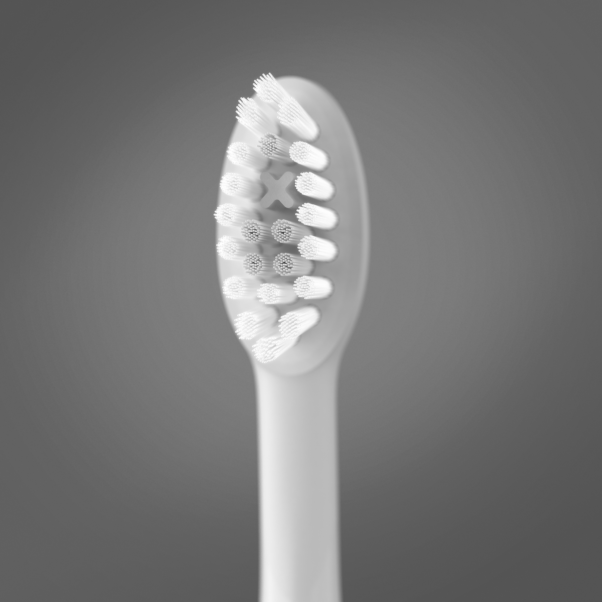 Primer plano de un cabezal de cepillo de dientes eléctrico blanco con cerdas sobre un fondo gris.