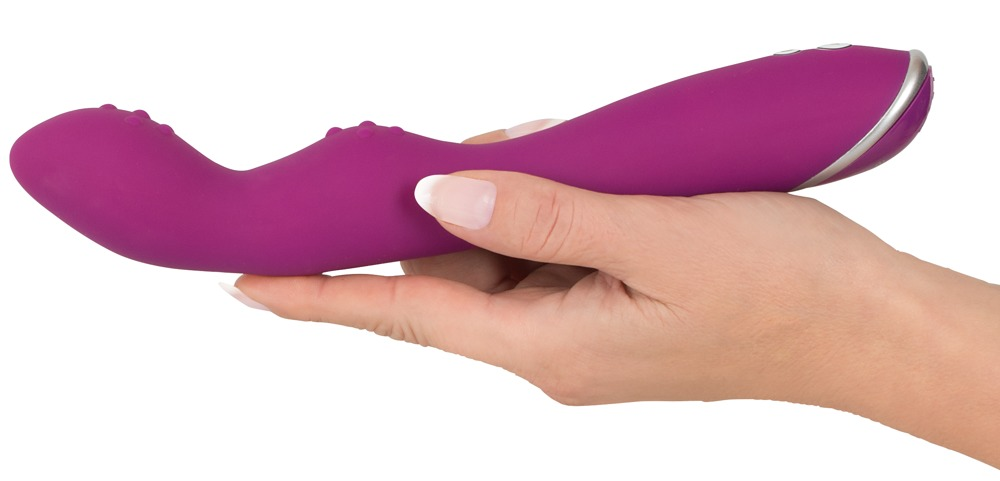 Eine Hand hält ein magentafarbenes, geschwungenes Vibrator-Sexspielzeug vor weißem Hintergrund.