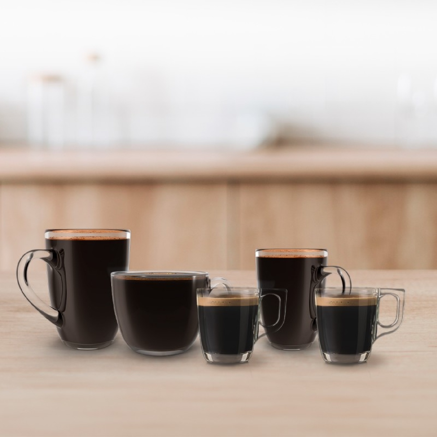 Cinque diverse tazze di vetro piene di caffè nero disposte su un tavolo di legno con sfondo della cucina sfocato.