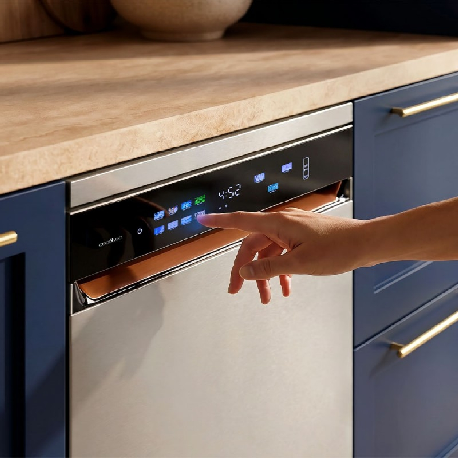 Una mano opera el panel de control digital de un lavavajillas plateado en una cocina azul con encimera de madera.