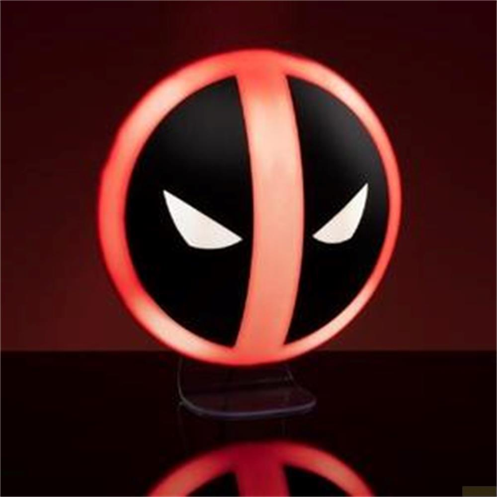 Eine kreisrund beleuchtete Deadpool-Lampe mit schwarzen Elementen und weißen, spitz zulaufenden Augen auf einem Tisch.