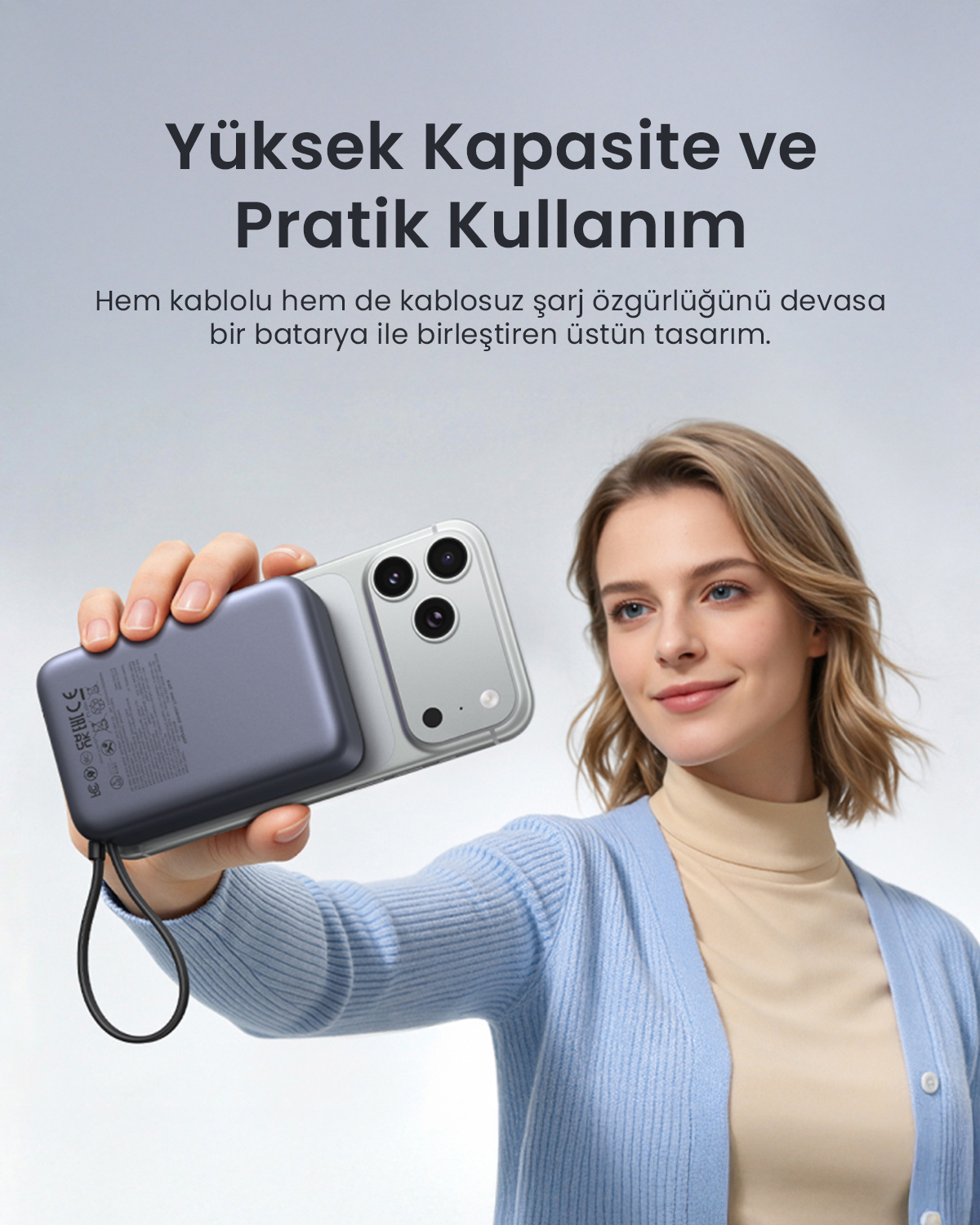 Bir kadın, arkasında manyetik taşınmaz şarj cihazı olan akıllı telefonu tutuyor.