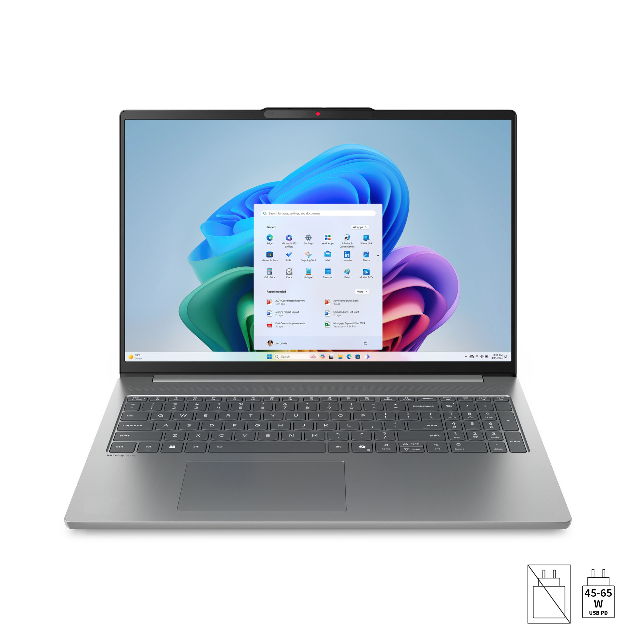 Ein silberner Laptop mit aufgeschaltetem Startmenü auf dem Bildschirm steht auf einer weißen Oberfläche.