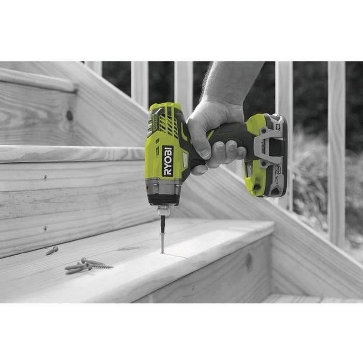 Una persona utilizza un avvitatore a impatto Ryobi per avvitare un gradino in legno.