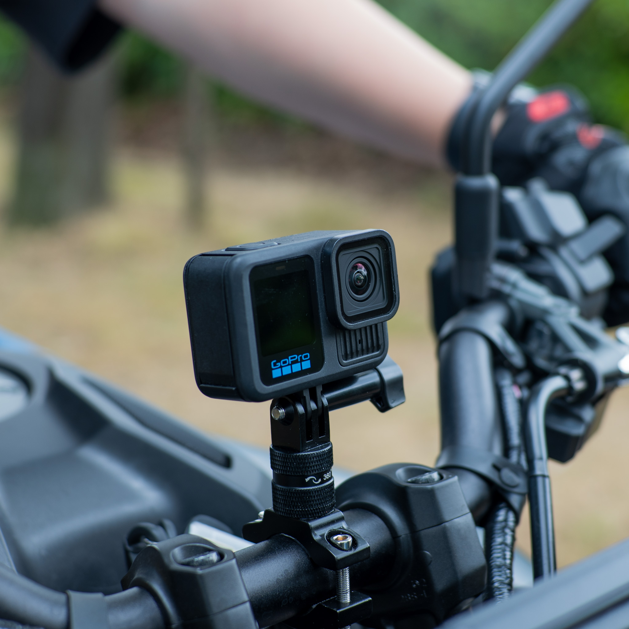 Een GoPro-camera gemonteerd op het stuur van een motorfiets met een wazige achtergrond.