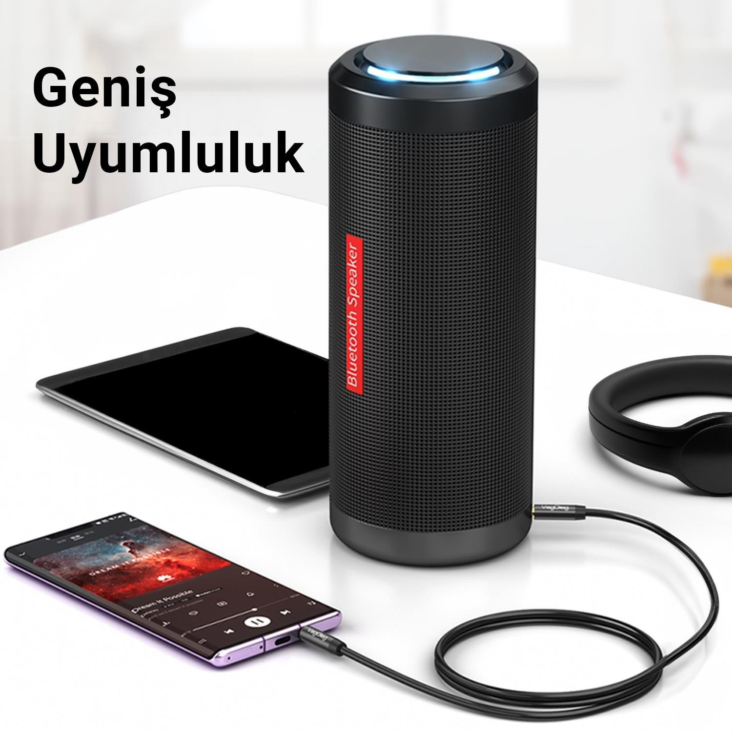 Masada kabloyla akıllı telefona bağlı siyah bir Bluetooth hoparlör.