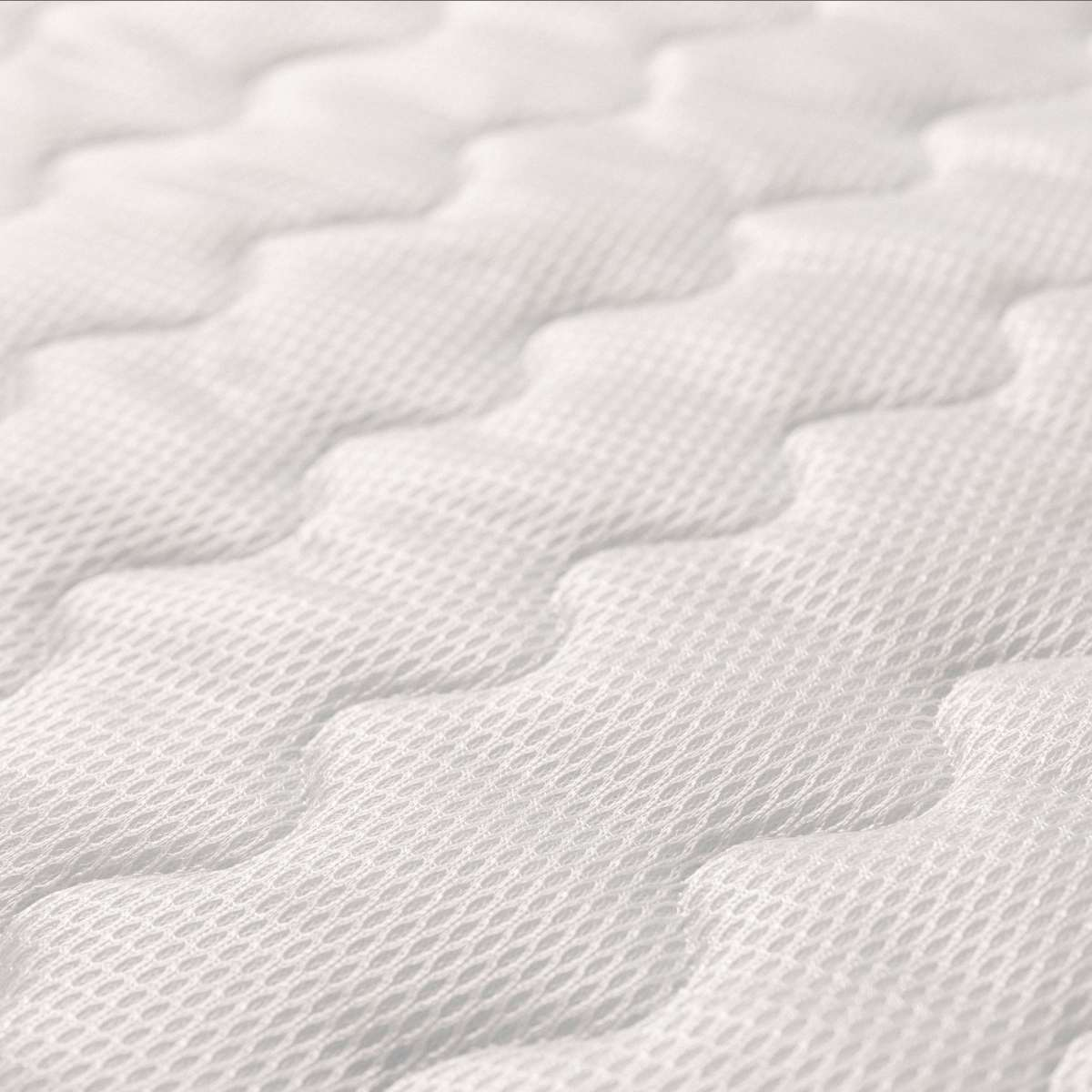 Primer plano de superficie de colchón blanca acolchada con patrón texturizado.