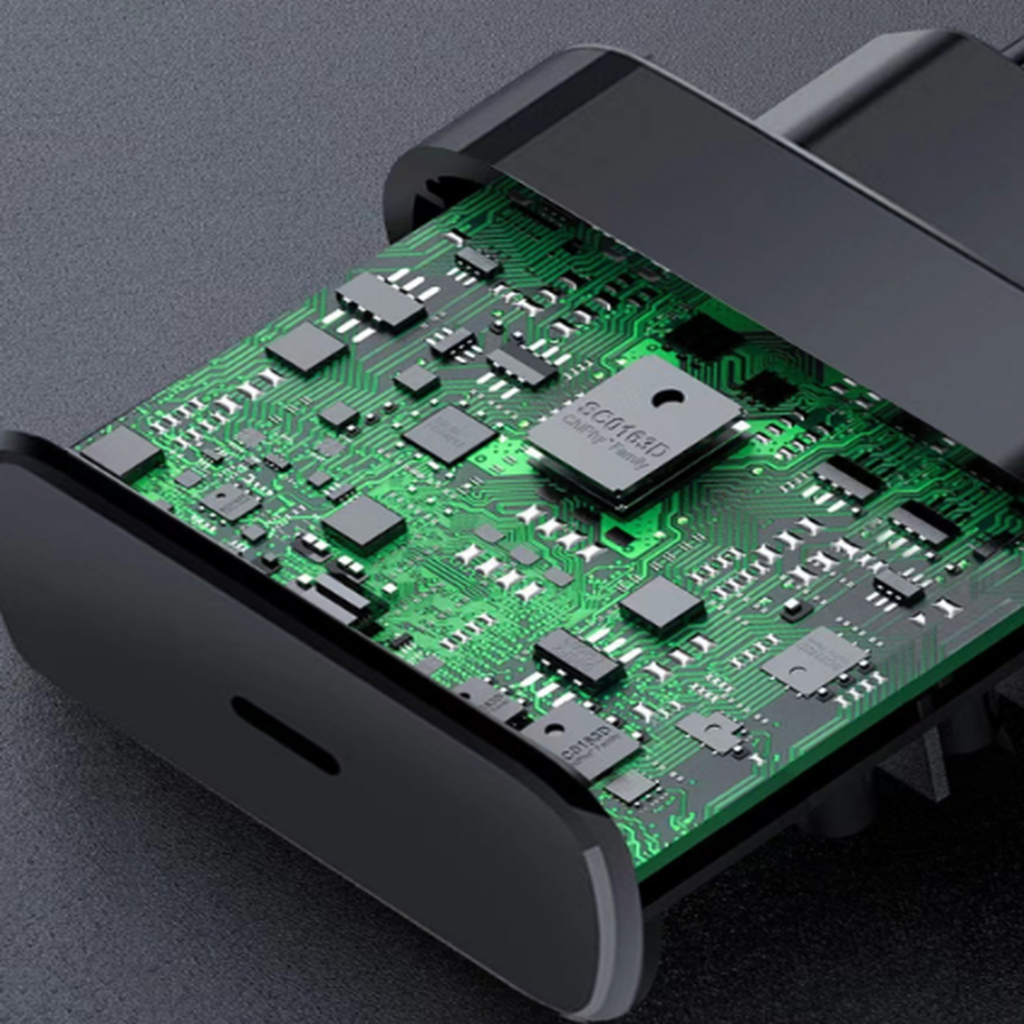 Nahaufnahme einer grünen Platine in einem schwarzen Gehäuse eines elektronischen Geräts.