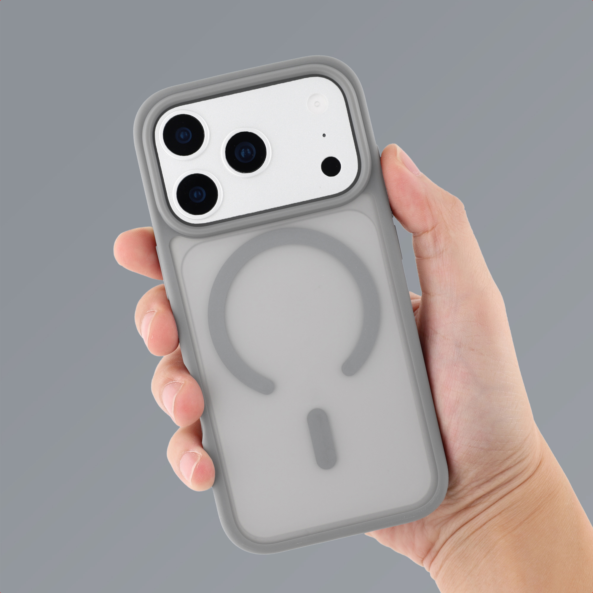 Eine Hand hält eine graue Smartphone-Hülle mit Kameraausschnitt und Magnetring.