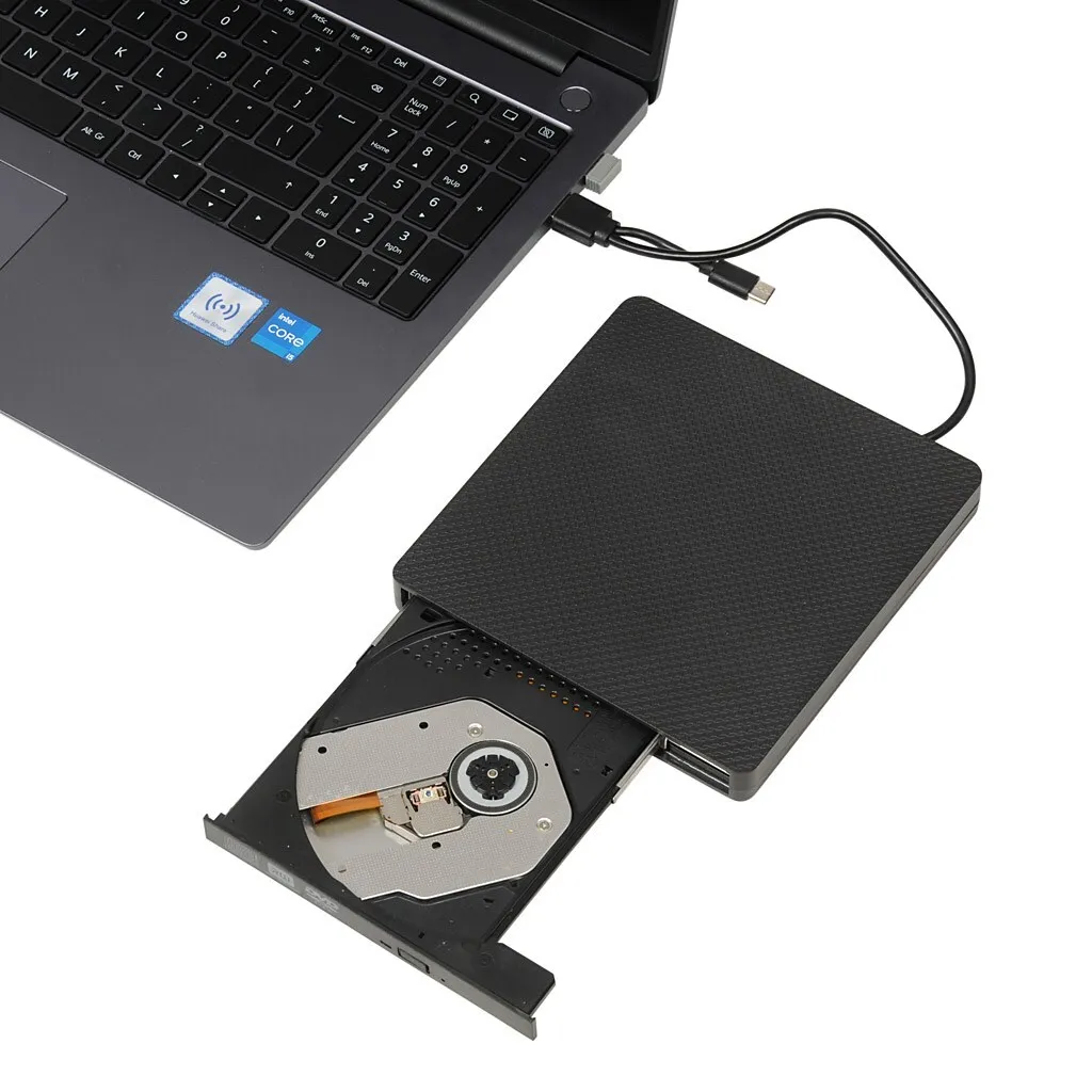 Ein schwarzes externes optisches Laufwerk, das über ein USB-Kabel an einen Laptop angeschlossen ist, mit geöffnetem Laufwerksschacht.