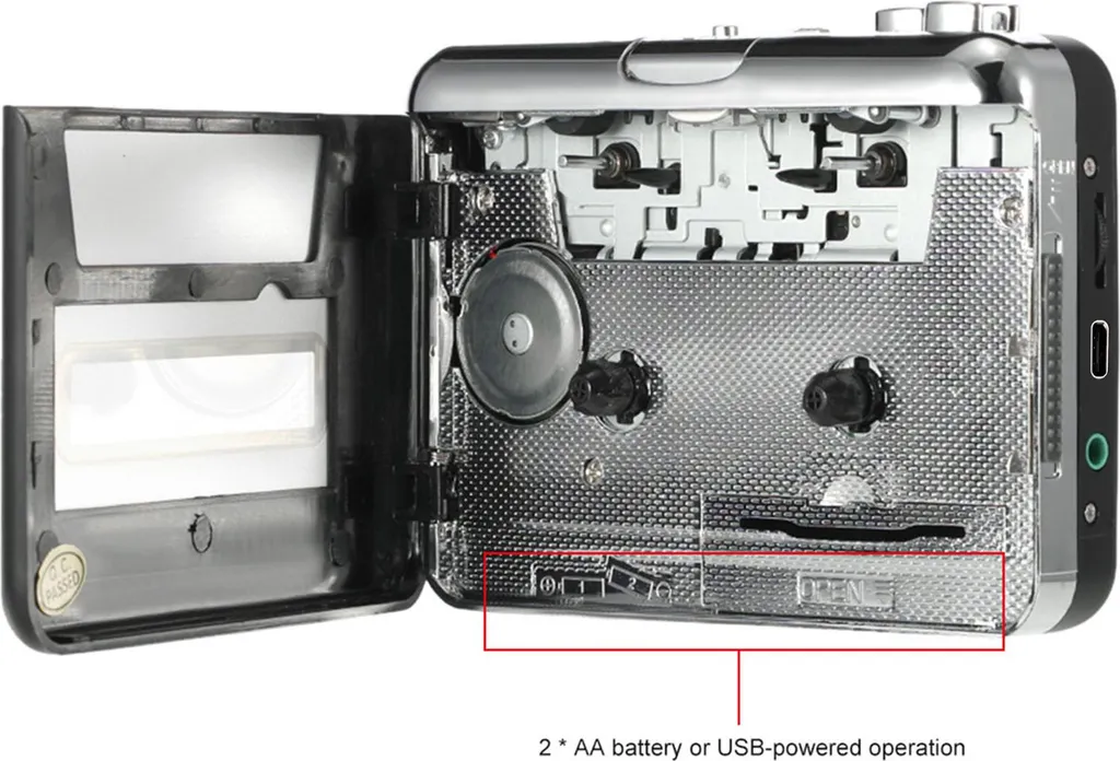 Ein offener Kassettenrekorder zeigt den inneren Mechanismus und ein Batteriefach für AA-Batterien.