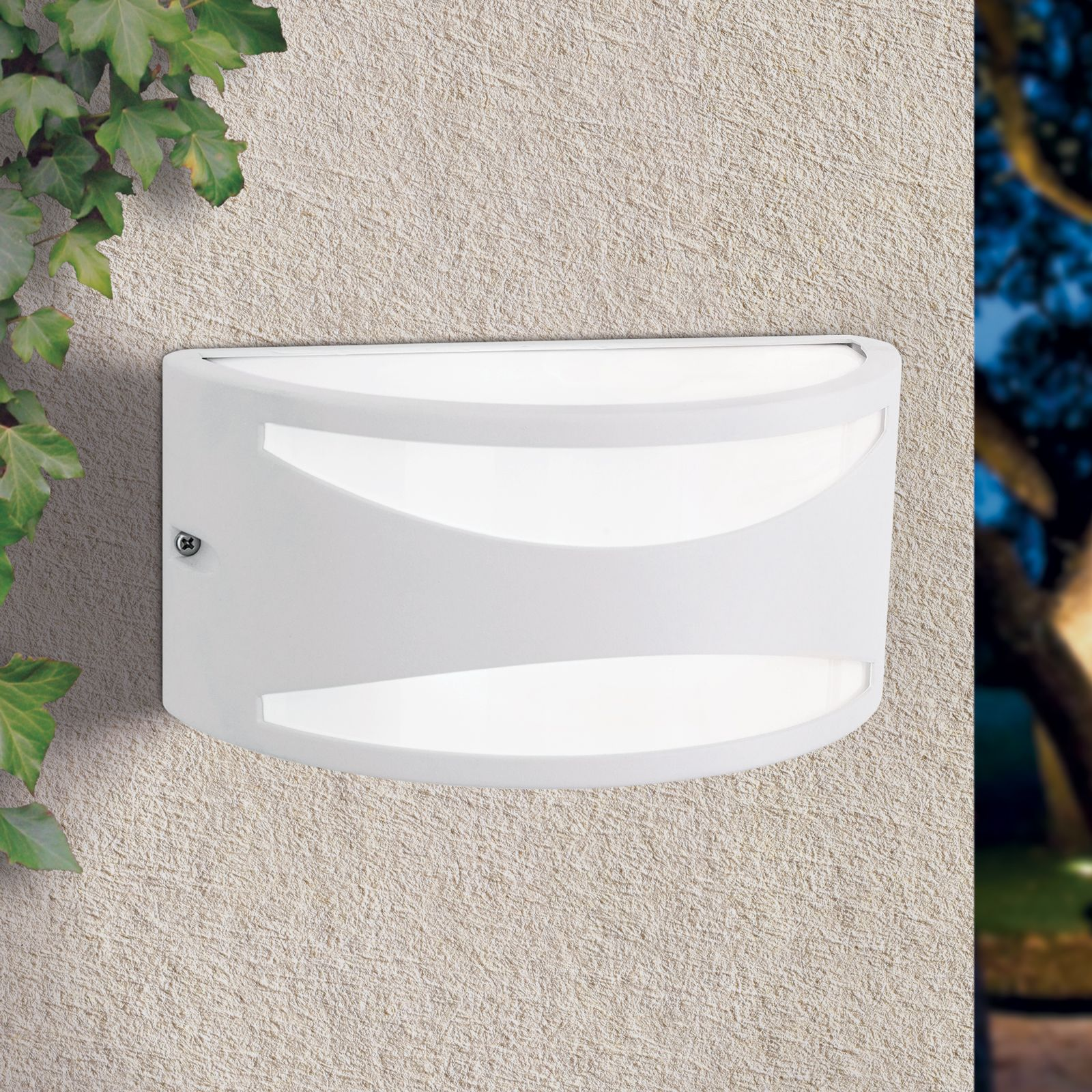 Eine weiße Außenwandleuchte mit gebogenem Design ist an einer hellen Putzwand montiert, mit Efeuranken an der Seite.