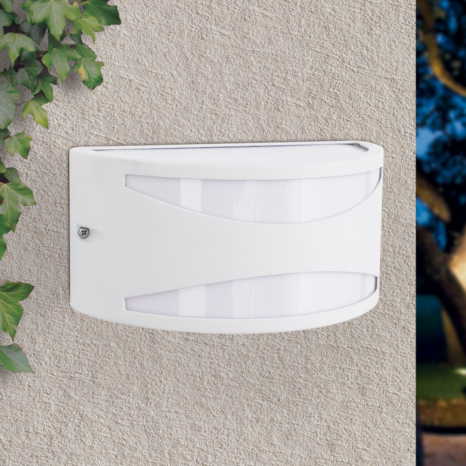 Eine weiße Wandleuchte mit zwei gebogenen Lichtschlitzen hängt an einer strukturierten Wand neben Efeuranken.