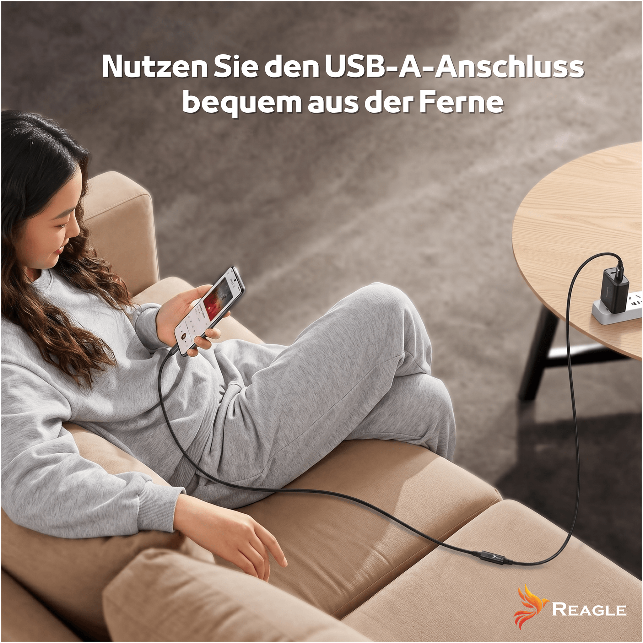 Una donna è seduta su un divano e usa uno smartphone collegato con un cavo.