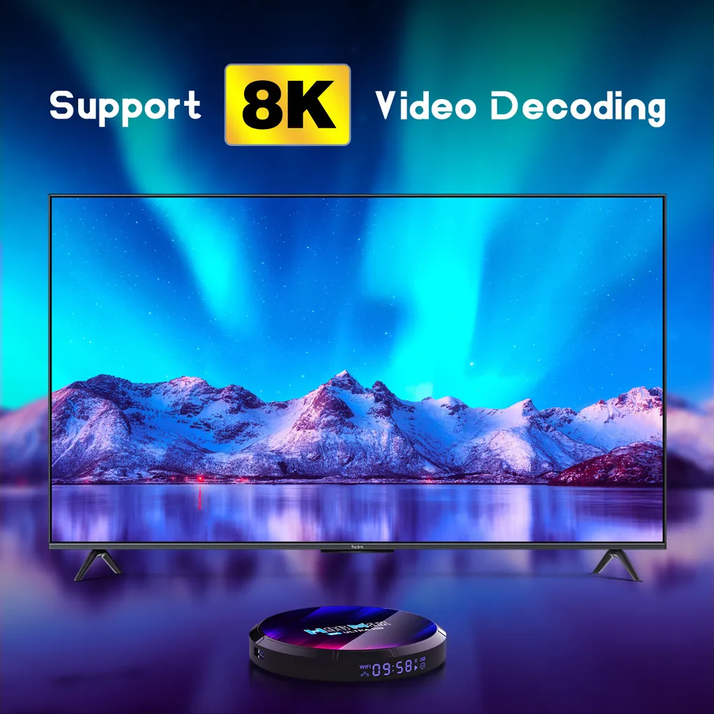 Ein Fernseher zeigt ein schneebedecktes Gebirge vor einer Nordlichtkulisse, davor steht eine runde TV-Box.
