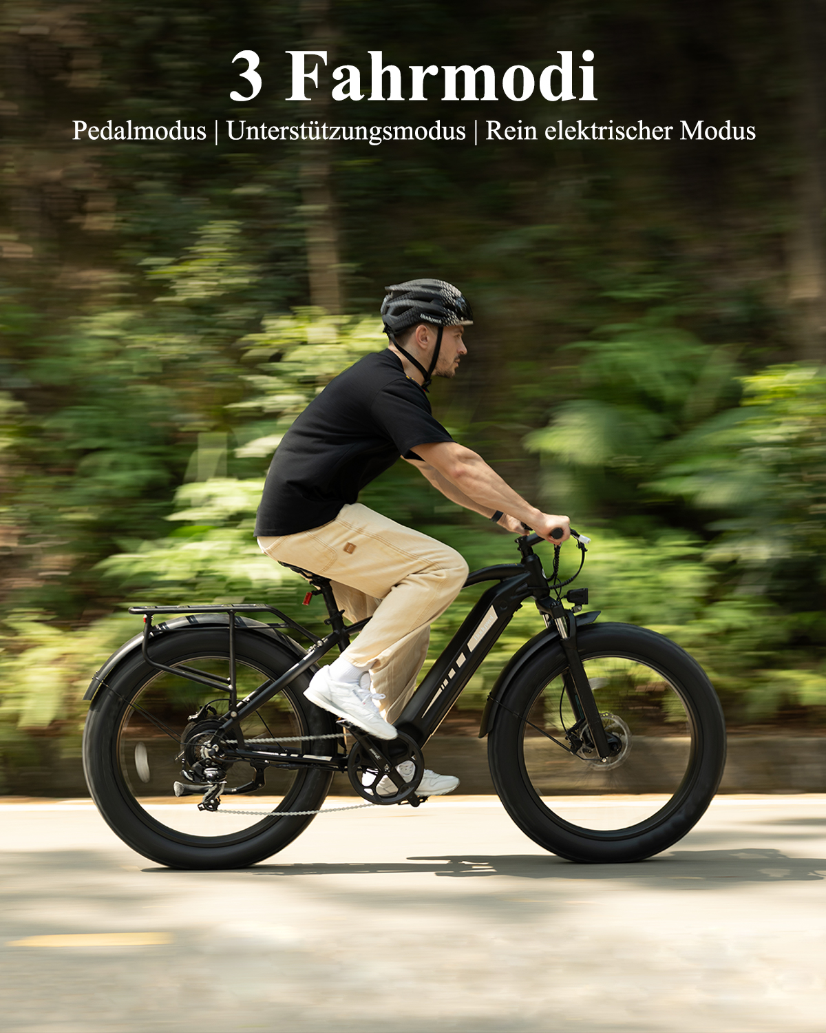 Ein Mann fährt ein schwarzes E-Bike auf einer Straße mit grünem Hintergrund.