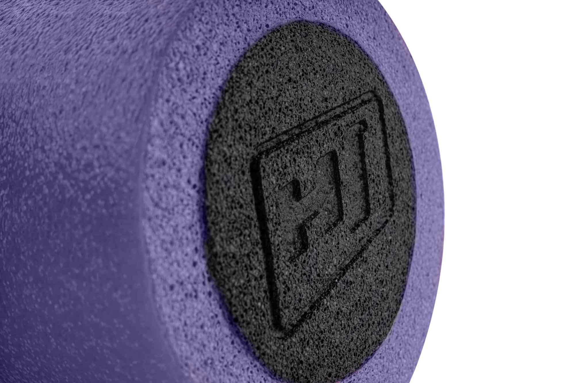 Nahaufnahme der flachen Seite einer violetten Schaumstoffrolle mit schwarzem kreisrundem Logo auf weißem Hintergrund.