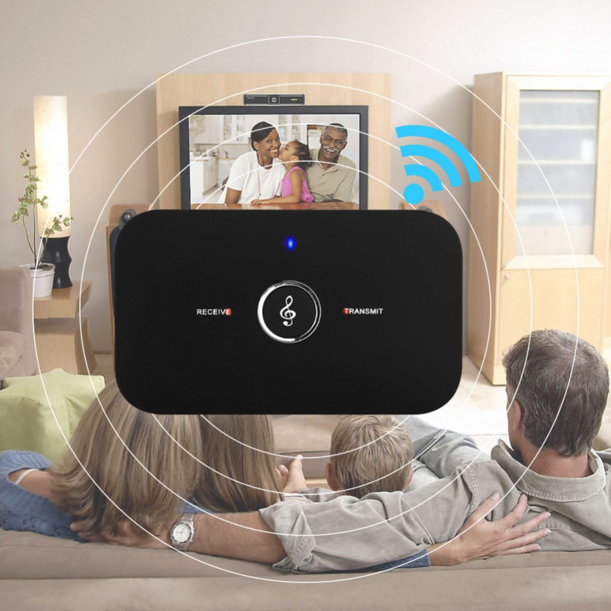 Eine Familie schaut Fernsehen im Wohnzimmer, verbunden durch ein kabelloses schwarzes Gerät mit blauer Anzeige.
