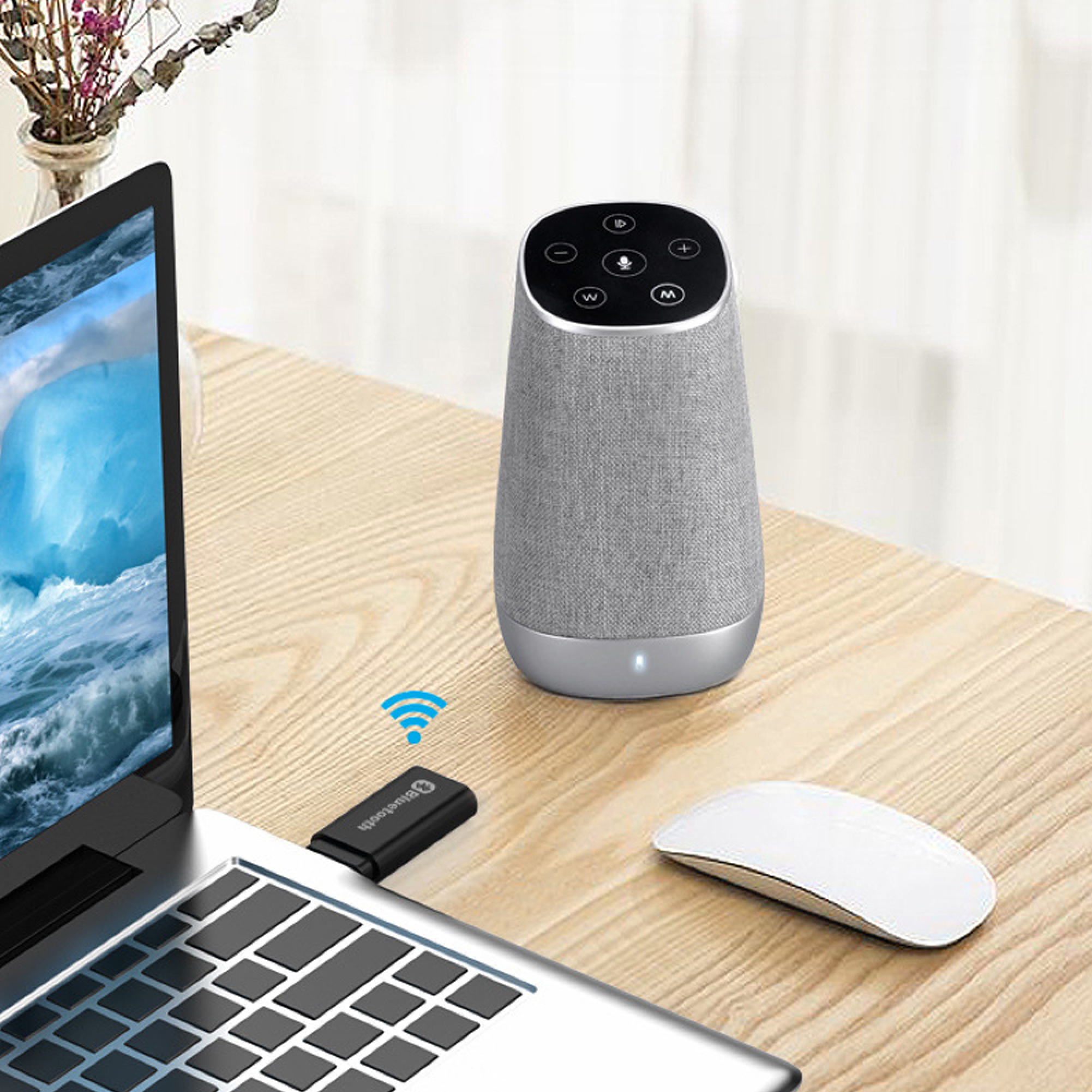 Laptop, Bluetooth-Dongle, weiße Maus und ein intelligenter Lautsprecher auf Holzschreibtisch.