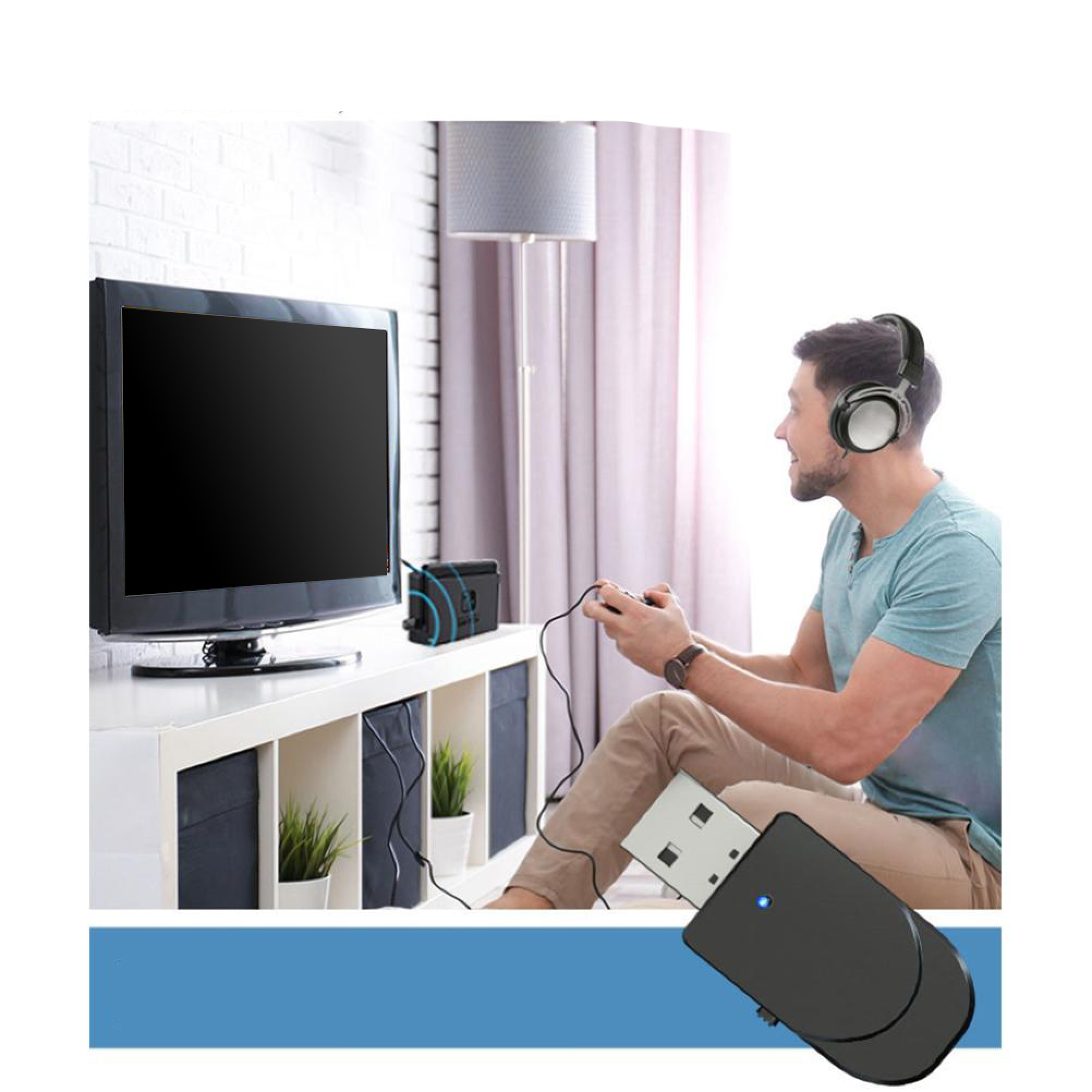 Ein Mann mit Kopfhörern spielt in einem Wohnzimmer Videospiele vor einem Fernseher und einer USB-Adapterkonsole.