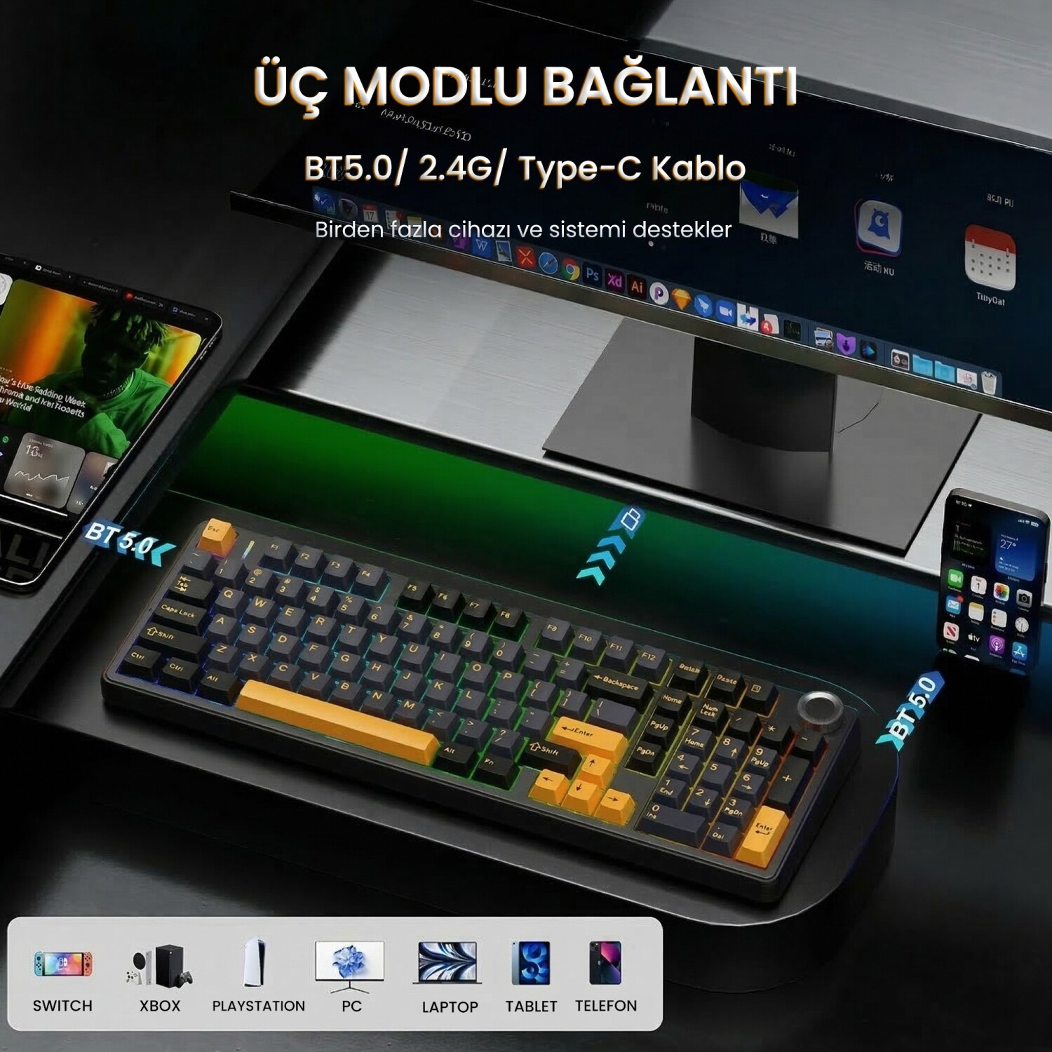 Monitör, tablet ve akıllı telefonun bulunduğu koyu renkli bir masada sarı detaylı siyah klavye.