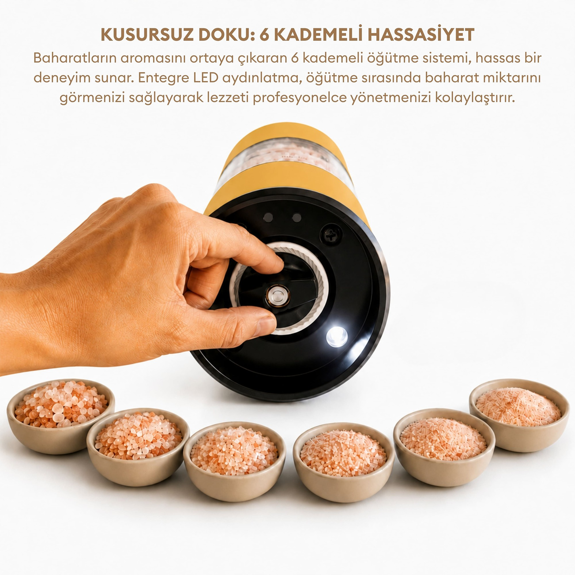 Bir el, sarı ve siyah baharat öğütücüyü ayarlıyor, önünde beyaz arka planda altı kase pembe tuz var.