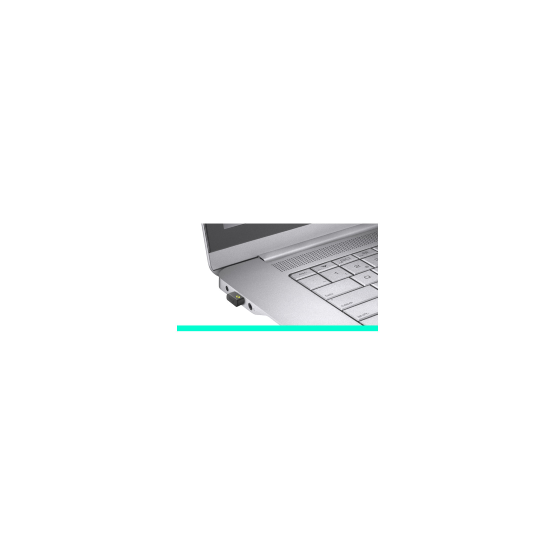Ein kleiner USB-Empfänger steckt in der Seite eines silbernen Laptops neben der Tastatur.