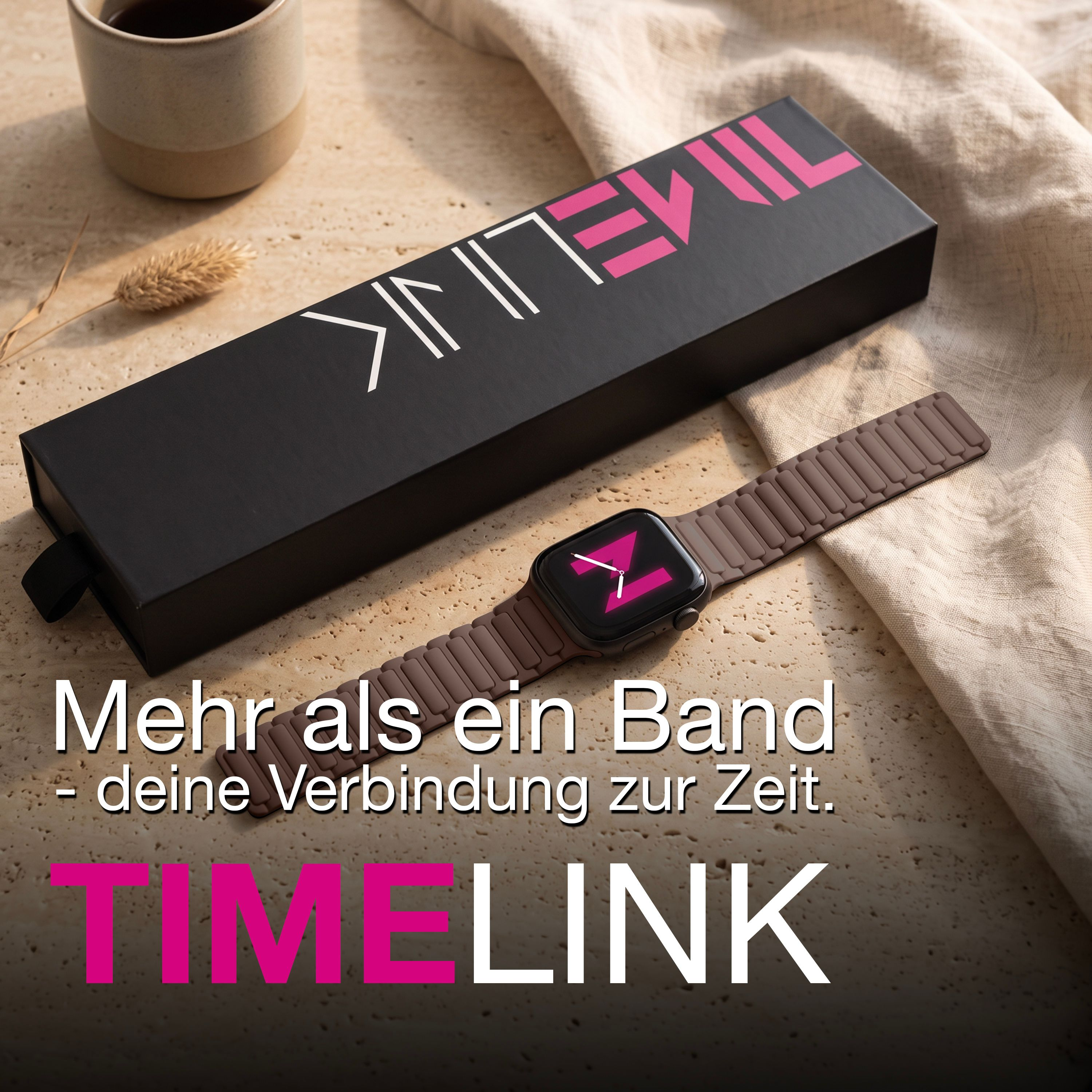 Eine Smartwatch mit braunem Armband neben einer schwarzen Schachtel und einer Tasse auf einem Tisch.