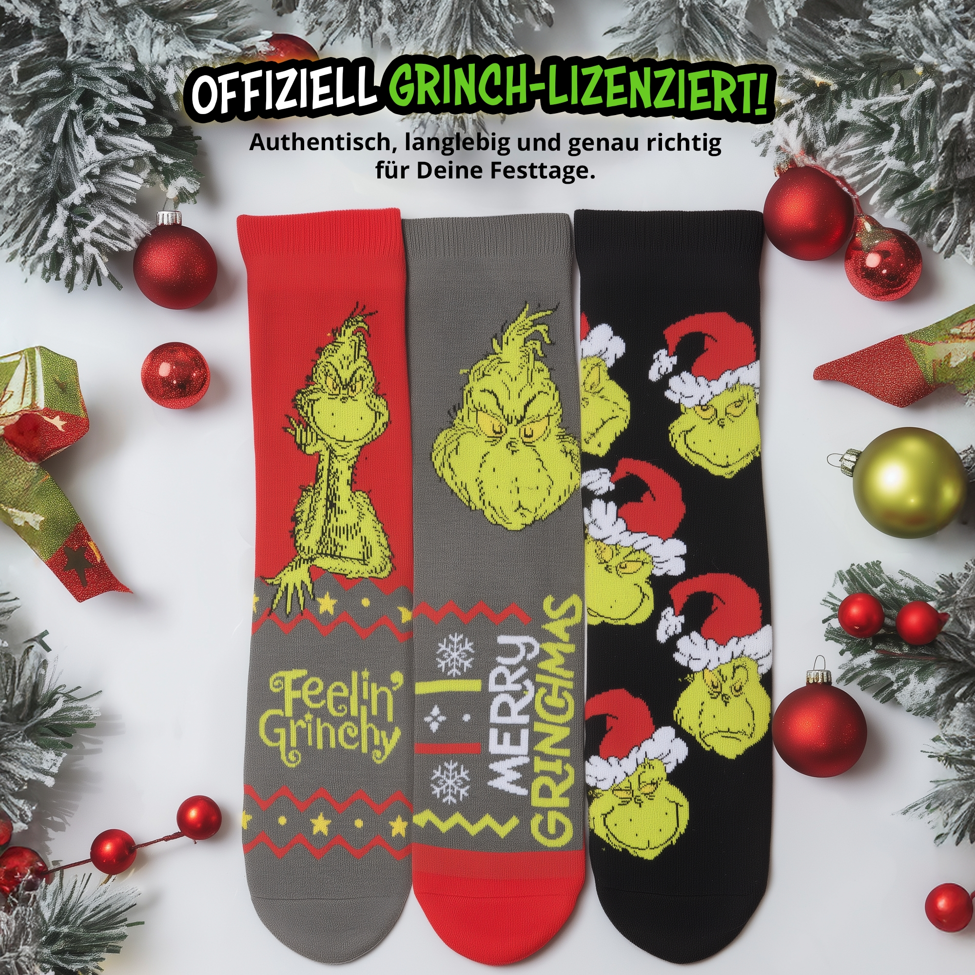 Drei Grinch-Socken auf weißem Hintergrund mit Weihnachtsschmuck wie Kugeln und Tannenzweigen.