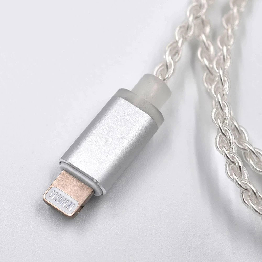 Beyaz arka planda örgülü gümüş kabloya sahip gümüş renkli Lightning konektörü.