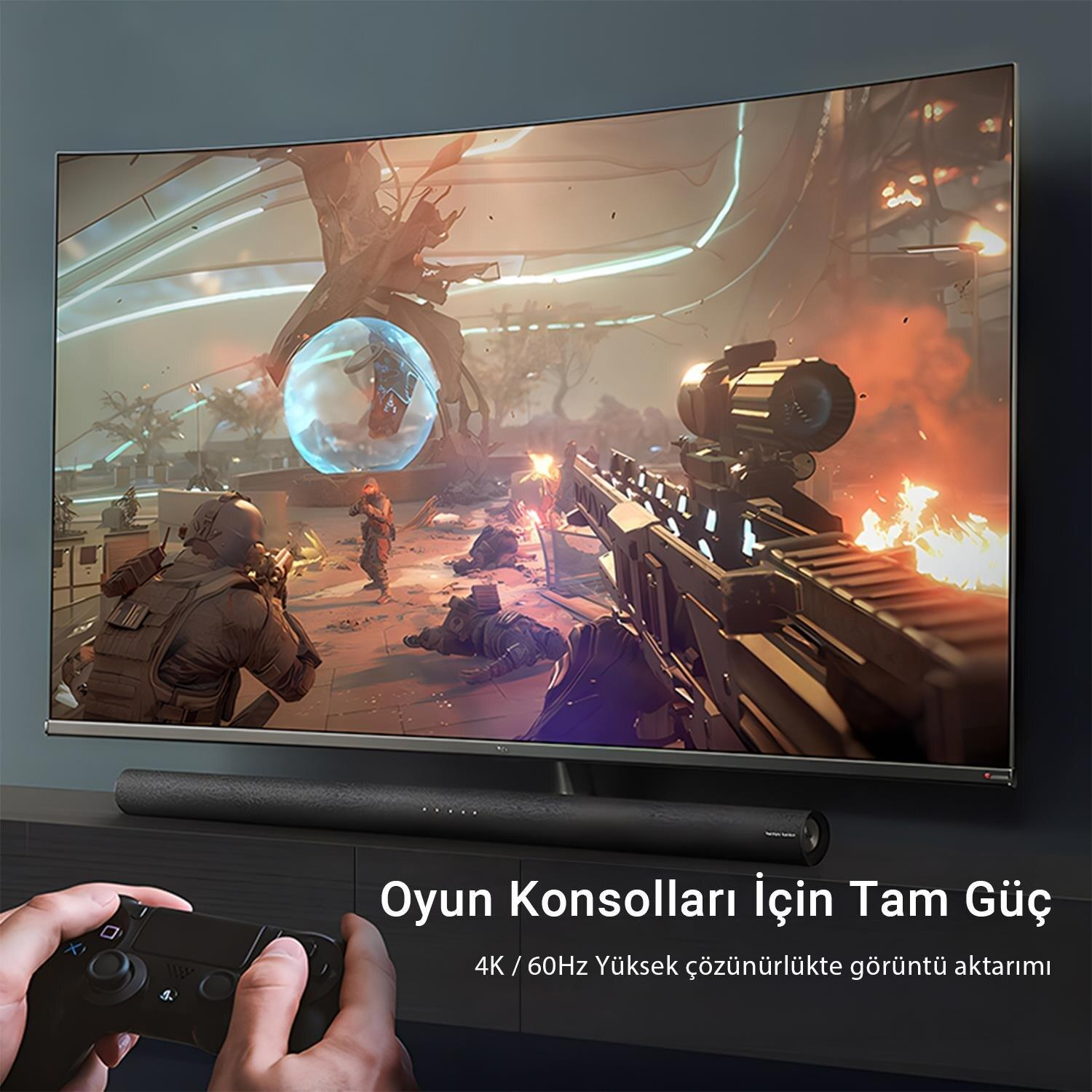 Bir oyuncu, video oyun sahnesi gösteren büyük kavisli bir TV'nin önünde kontrol cihazı tutuyor.