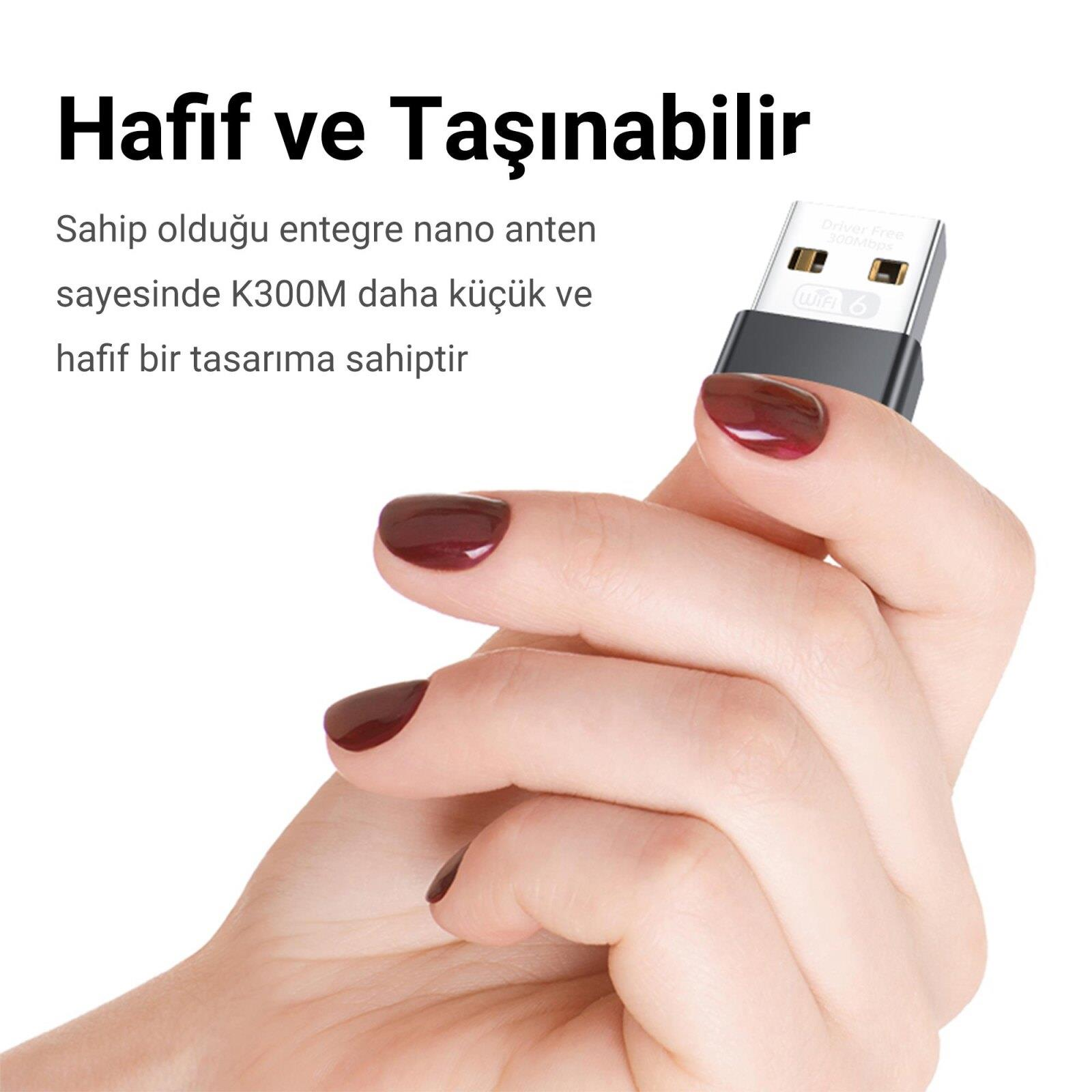 Koyu oje sürmüş el, beyaz arka planda küçük bir Wi-Fi USB adaptörü tutuyor.