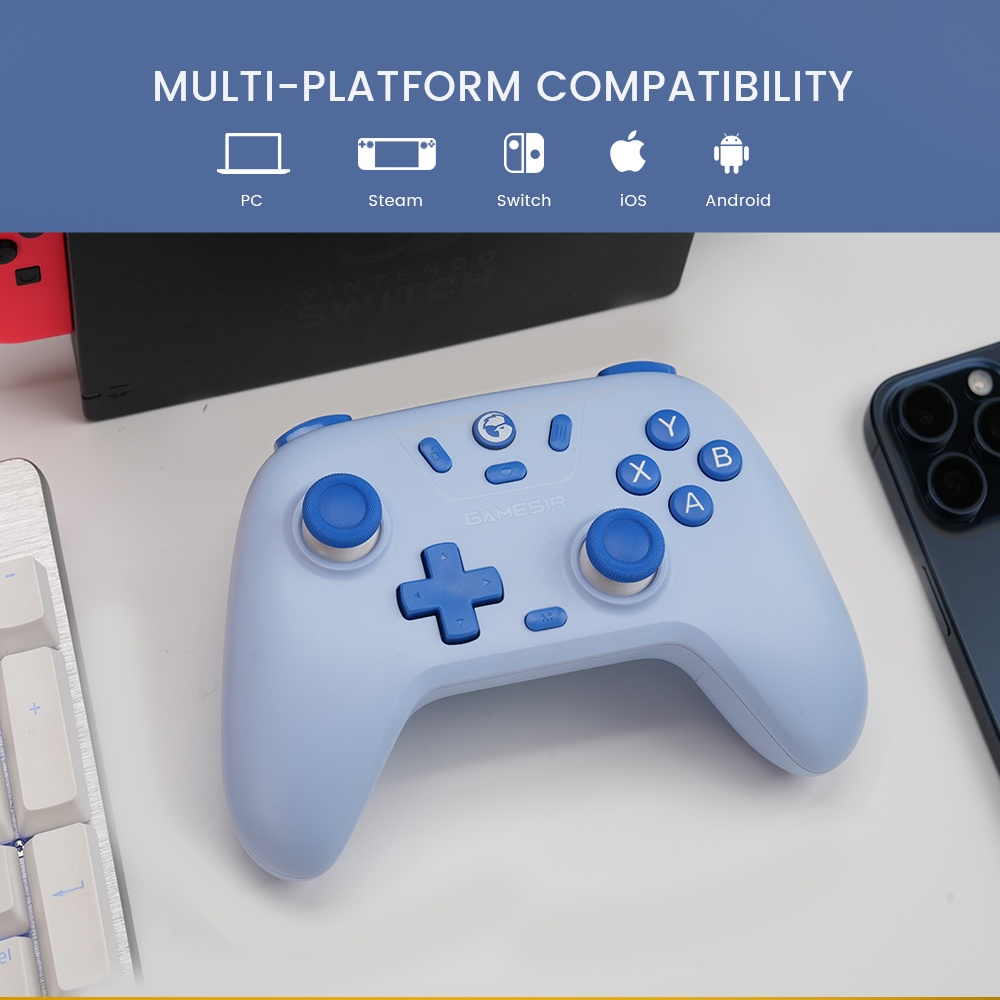 Un controller GameSir azzurro su una scrivania bianca con tastiera, telefono e console Switch. Icone multi-piattaforma in alto.