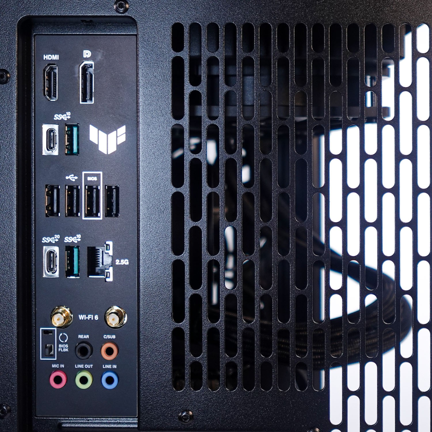 Rückseite eines Computergehäuses mit I/O-Anschlüssen, HDMI, USB, Audiobuchsen und Lüftungsgittern.
