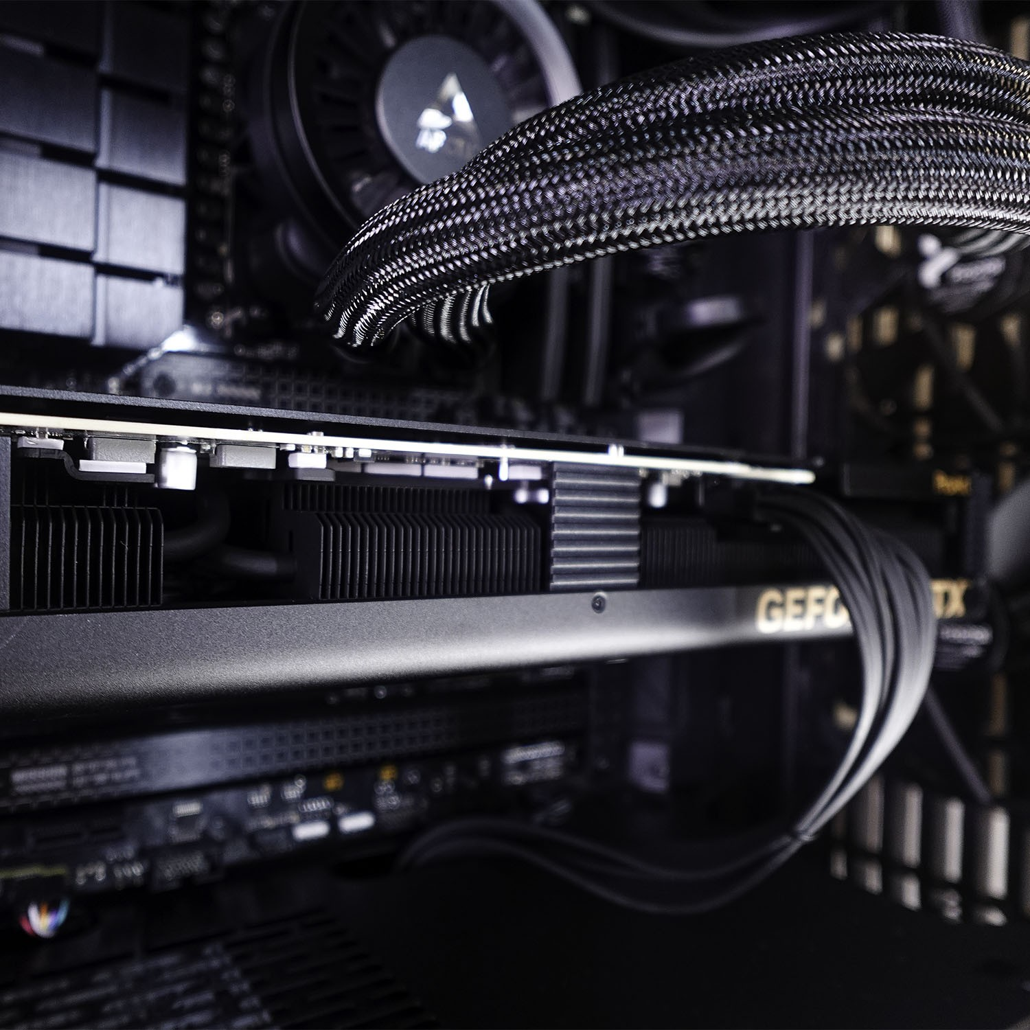 Nahaufnahme eines Gaming-PCs mit GeForce-Grafikkarte, Kühlern und geflochtenen Schläuchen im Inneren.