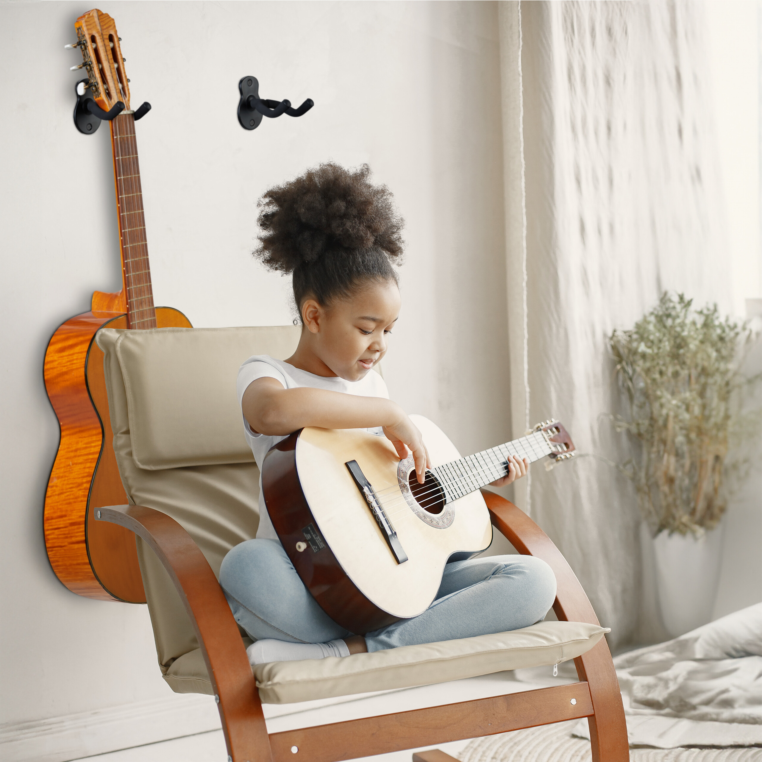Ein junges Mädchen mit hochgesteckten Haaren sitzt in einem Sessel und spielt akustische Gitarre.