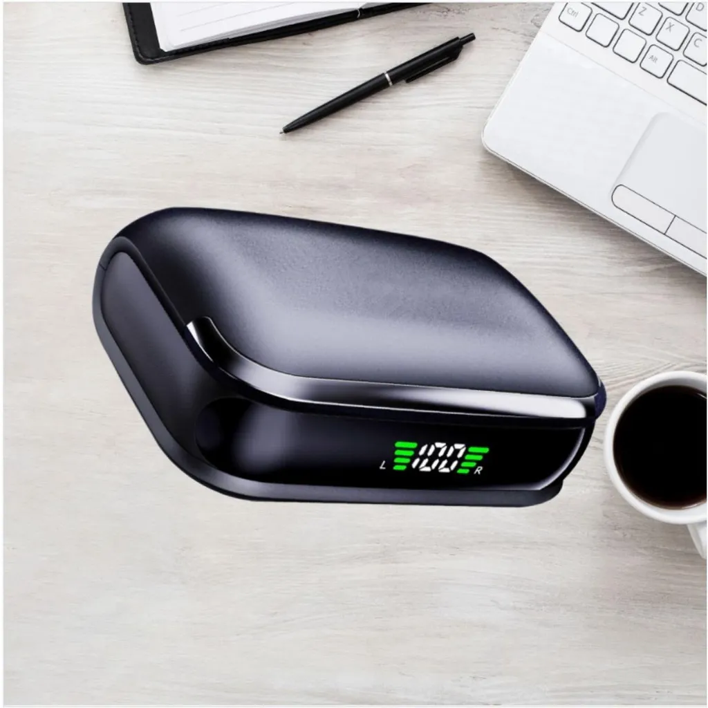 Ein schwarzes Ladecase mit digitaler Anzeige liegt auf einem Holztisch neben Laptop und Tasse.