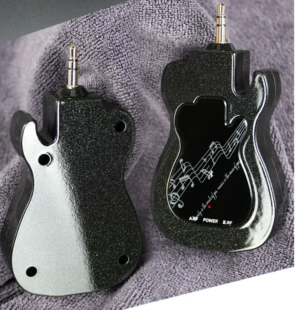 Zwei schwarze, gitarrenförmige Audiogeräte mit Klinkenstecker auf grauem Handtuch.