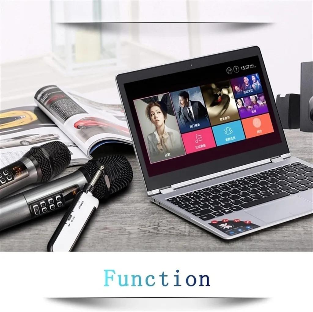 Ein grauer Laptop mit Karaoke-Software, zwei Mikrofone und ein offenes Magazin liegen auf einem Holztisch.