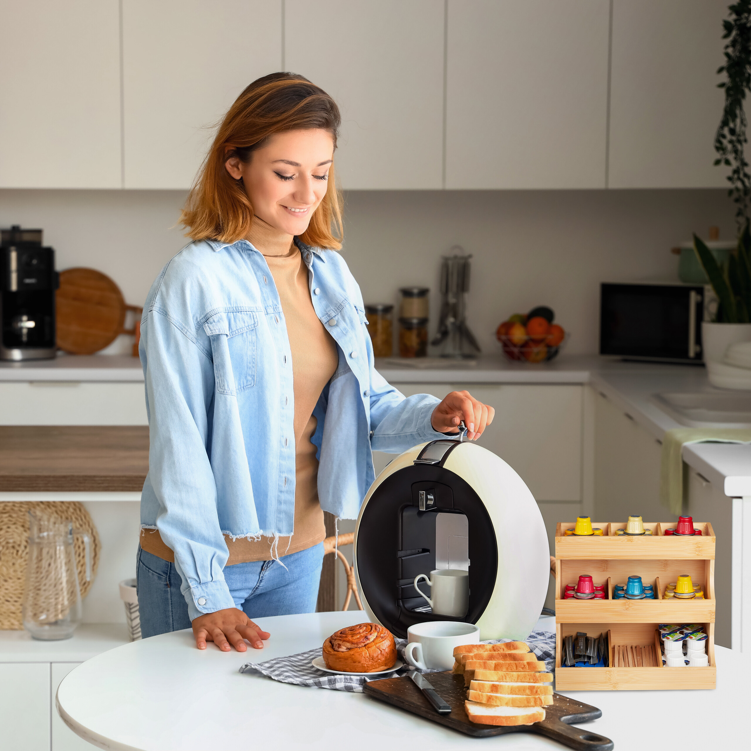 Eine Frau in der Küche bereitet Kaffee zu, mit Gebäck und Toast auf dem Tisch.