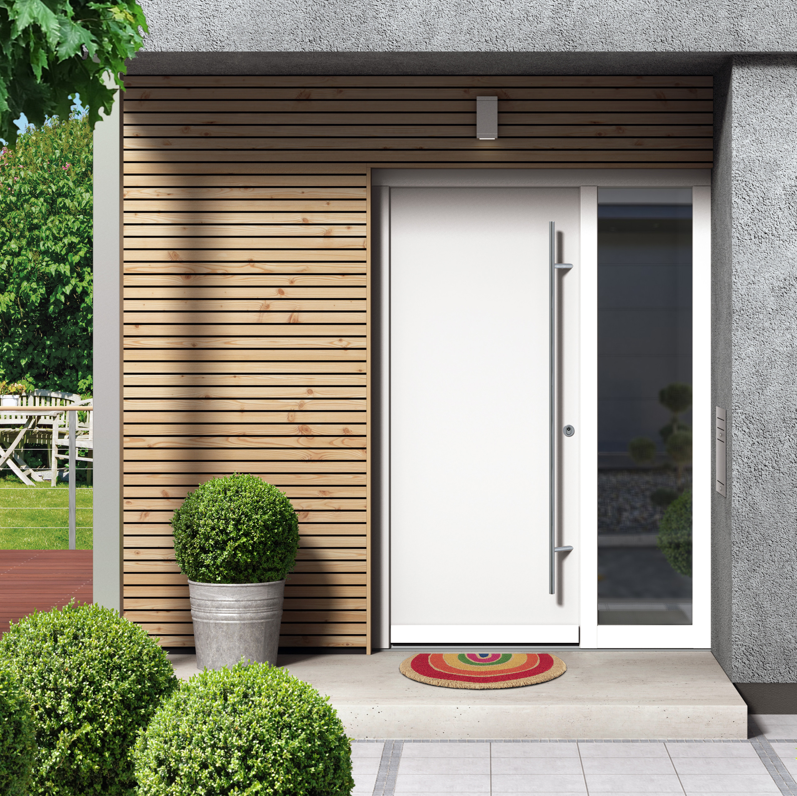 Moderne weiße Haustür mit Holzverkleidung, Pflanzenkübeln und bunter Fußmatte.