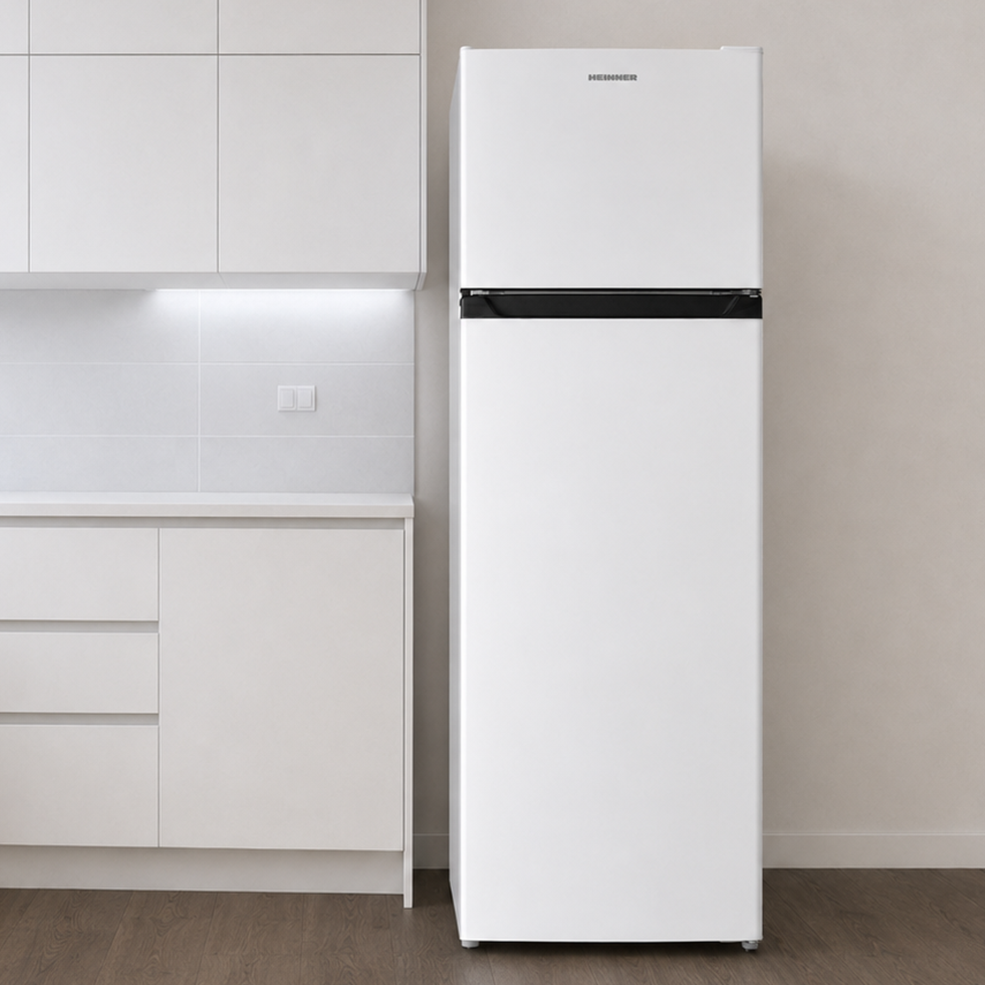 Un réfrigérateur blanc se trouve dans une cuisine blanche moderne avec un sol en bois.