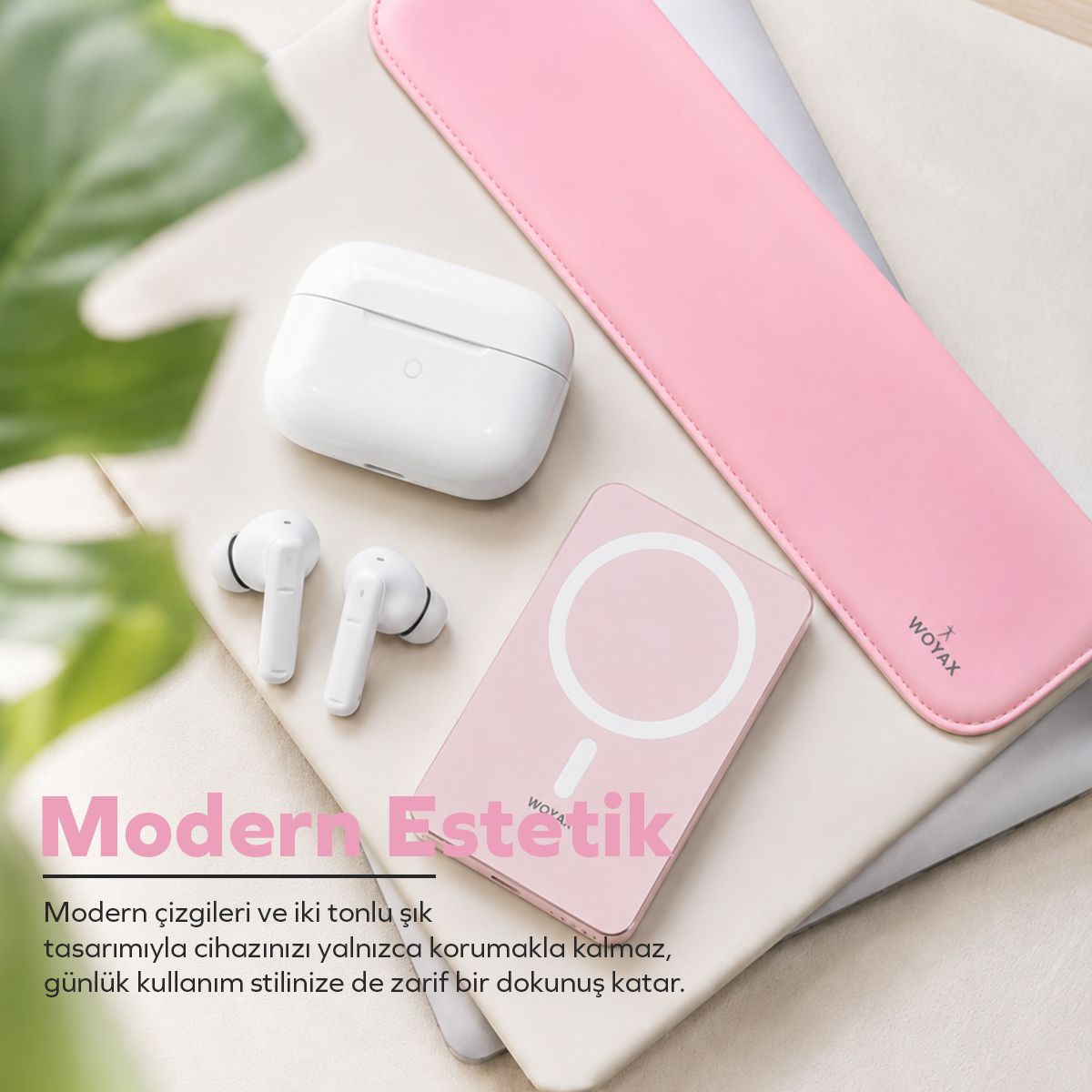 Kutuda beyaz kablosuz kulaklık, pembe powerbank ve pembe laptop kılıfı bej yüzeyde.