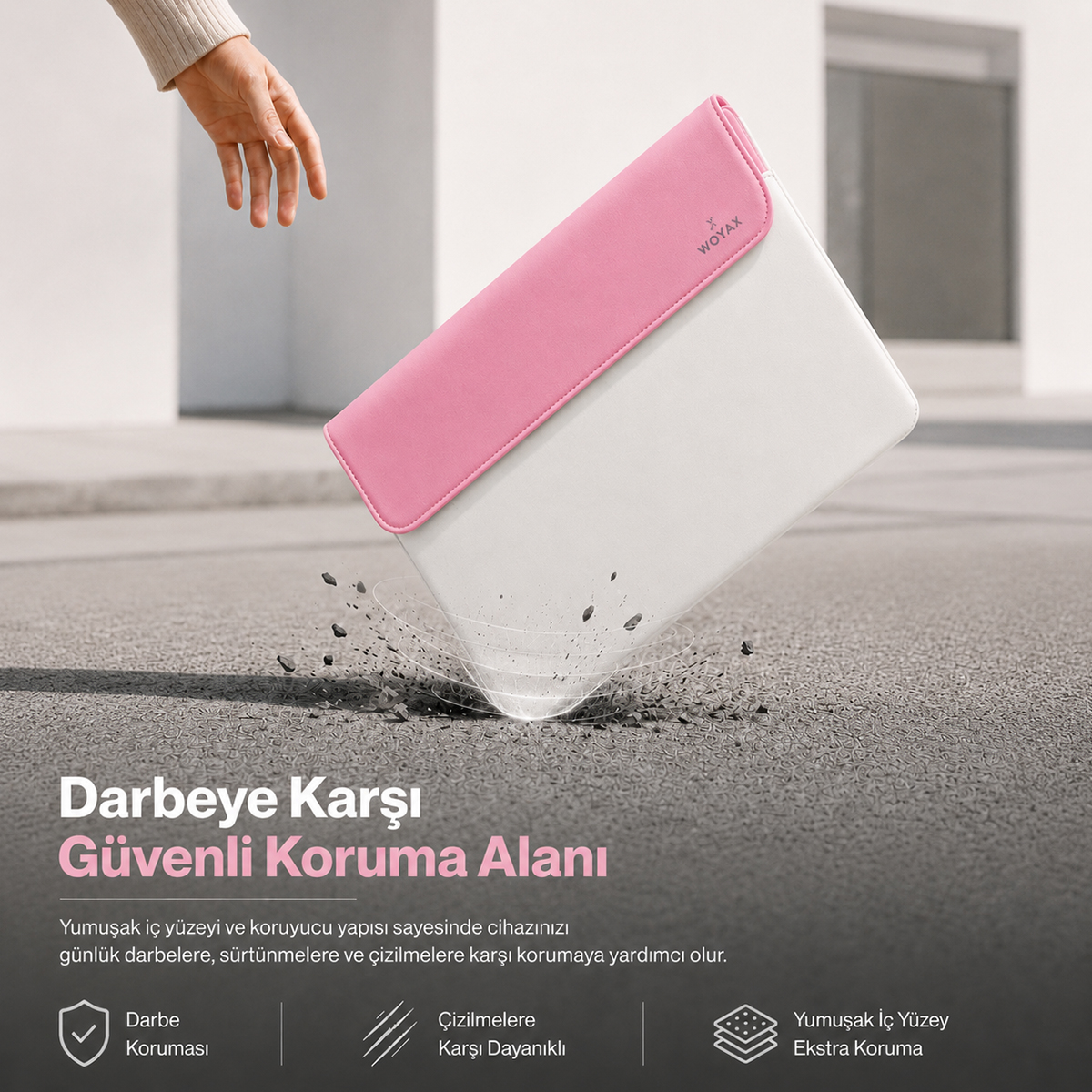 Pembe kapaklı beyaz bir laptop kılıfı yere düşüyor, etrafında toprak parçacıkları var.