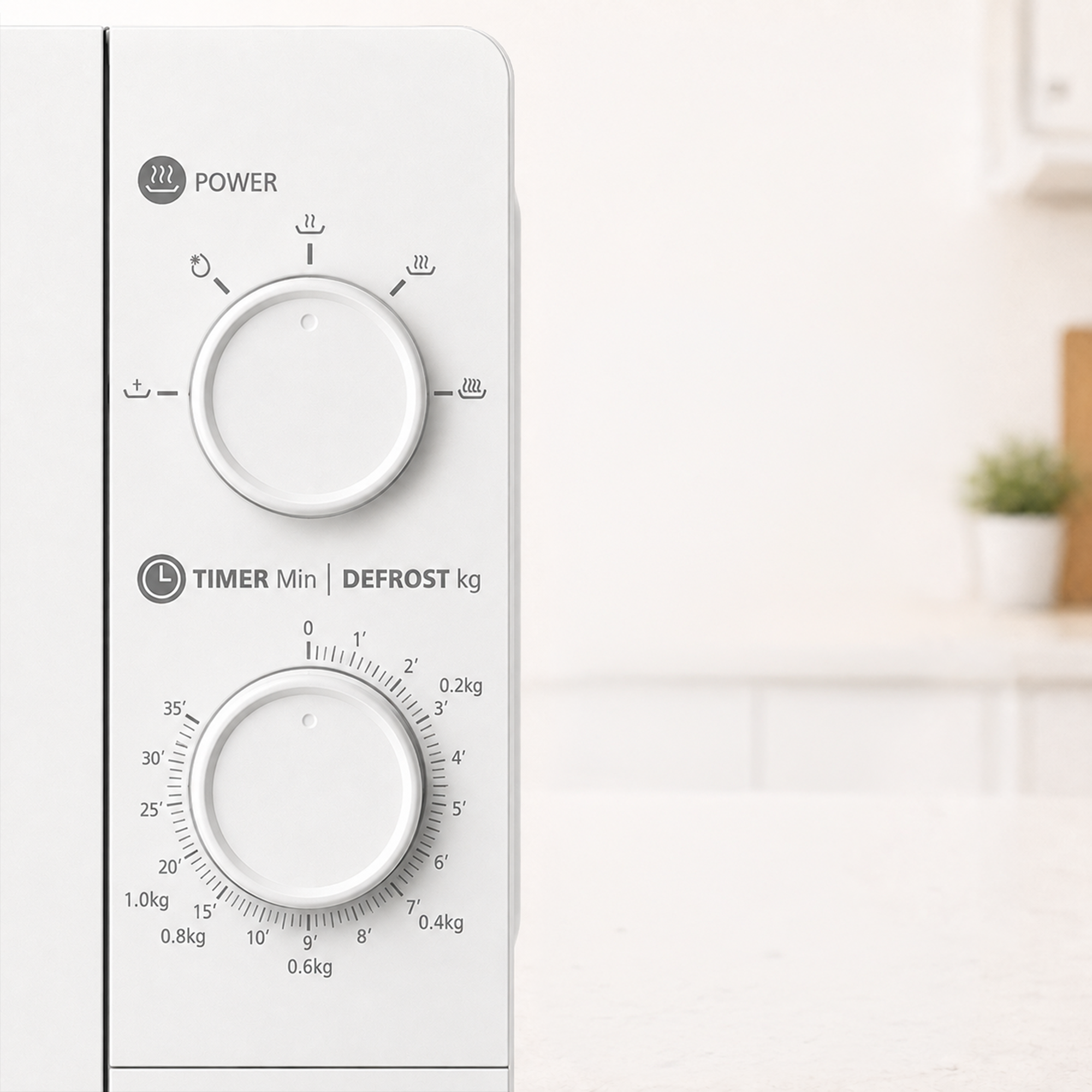 Close-up of a white microwave control panel with two rotary knobs for power and timer/defrost in a kitchen.