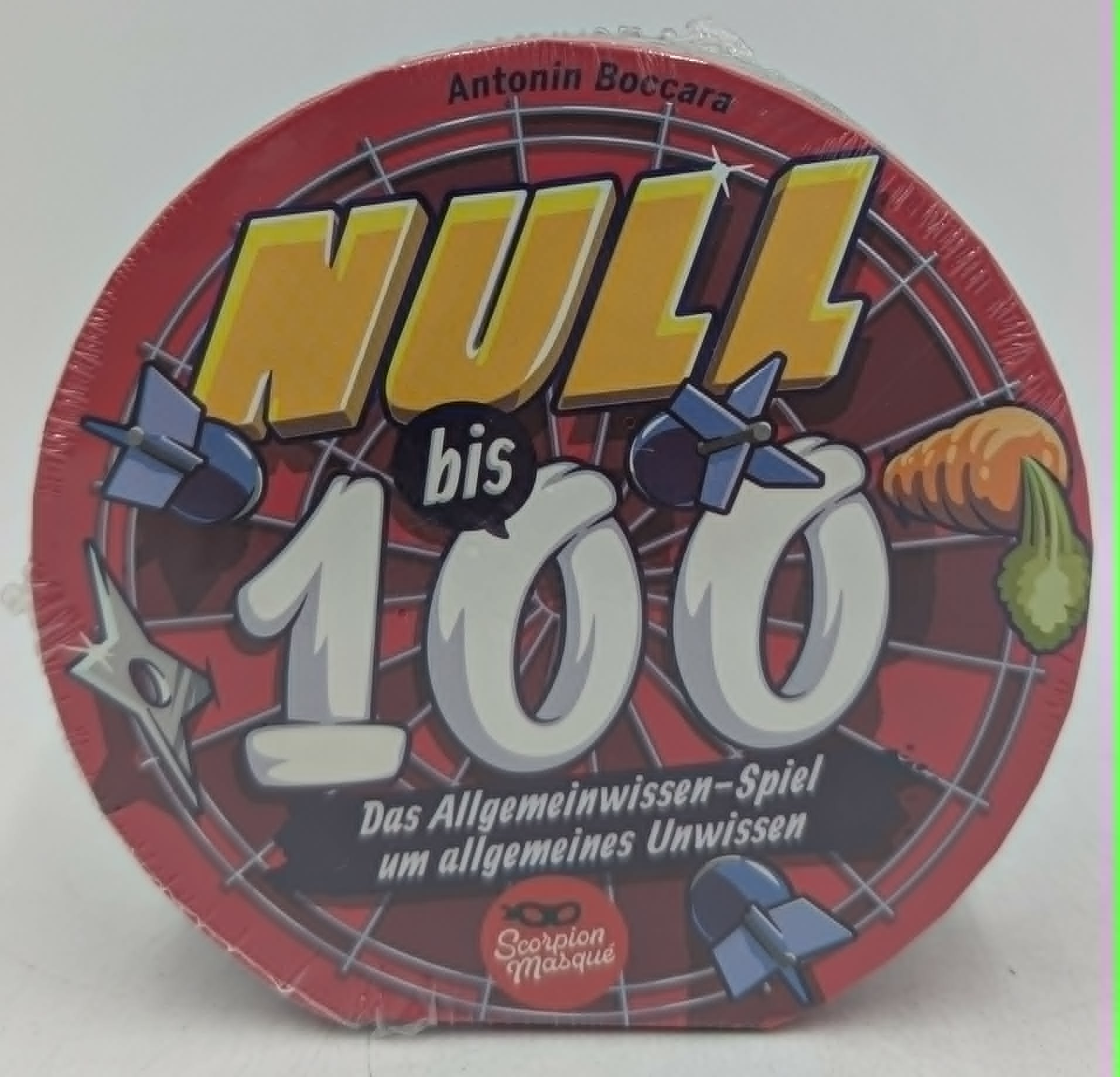 Runde Brettspielschachtel in Rot mit gelben und weißen Aufschriften wie NULL bis 100 und kleinen Illustrationen.