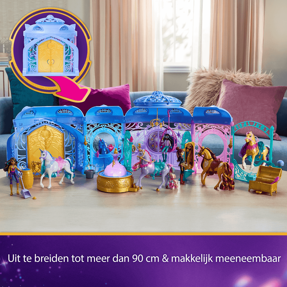 Ein blaues Spielset mit Puppen, Einhörnern und Zubehör vor einem Sofa.