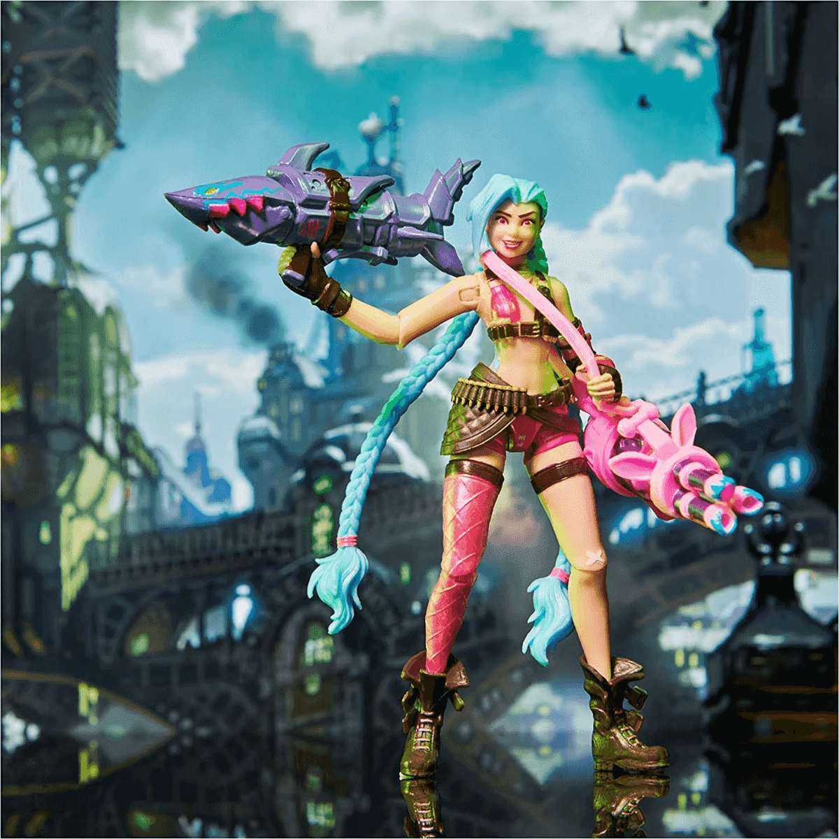 Jinx-Actionfigur mit blauen Haaren und Waffen vor einer Stadtkulisse.